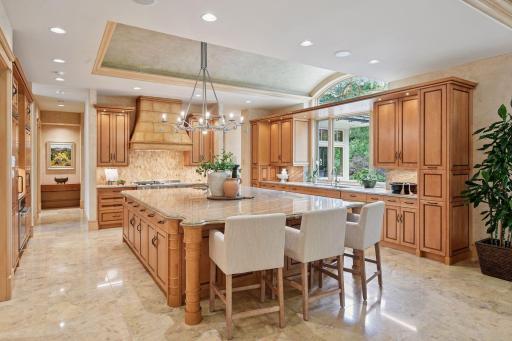Kitchen filled with abundant natural light, featuring an oversized window above the sink and extensive cabinetry throughout.
