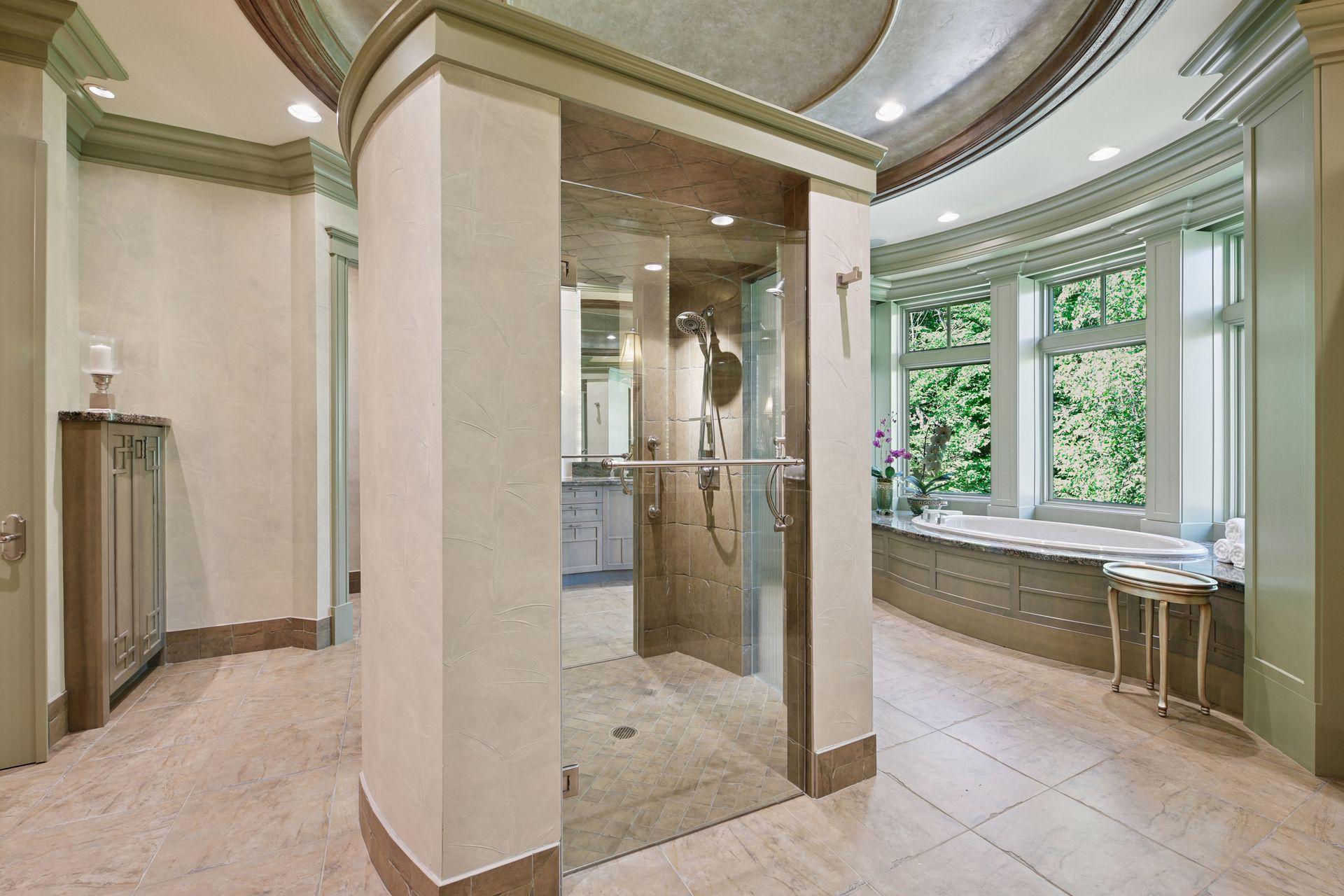 Elegant primary bath offering an oversized shower, deep soaking tub, dual water closets, and two well-appointed vanities with extensive storage.