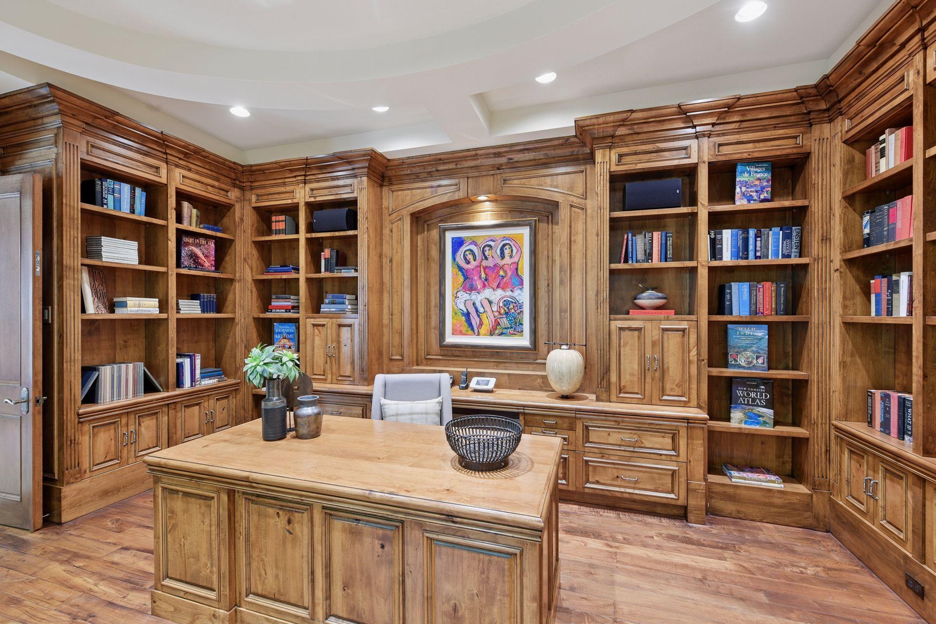 Elegant office with rich wood finishes, showcasing custom shelving and cabinets that keep electronics out of sight.