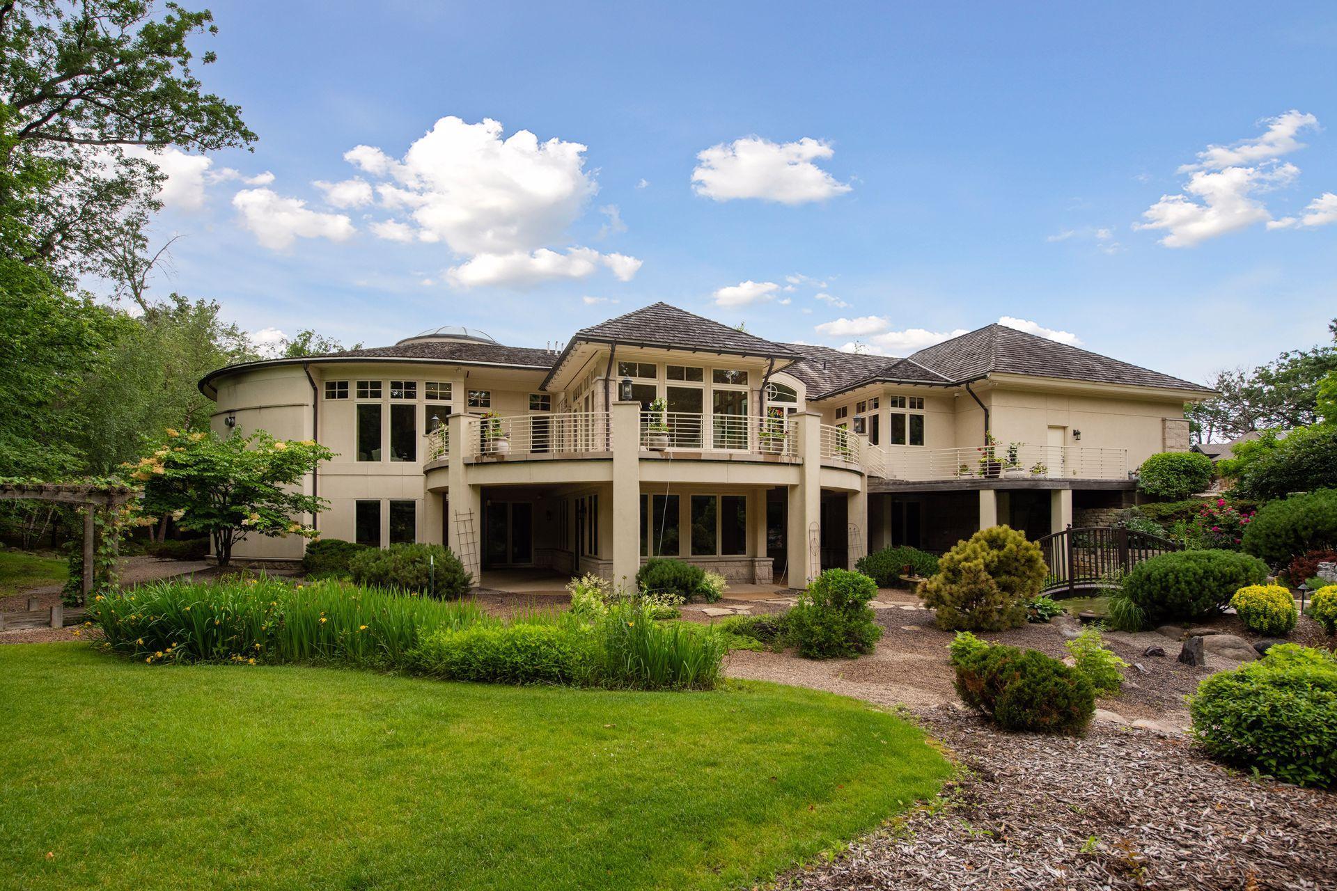 Lawn and gardens with path to bench on far side of pond.