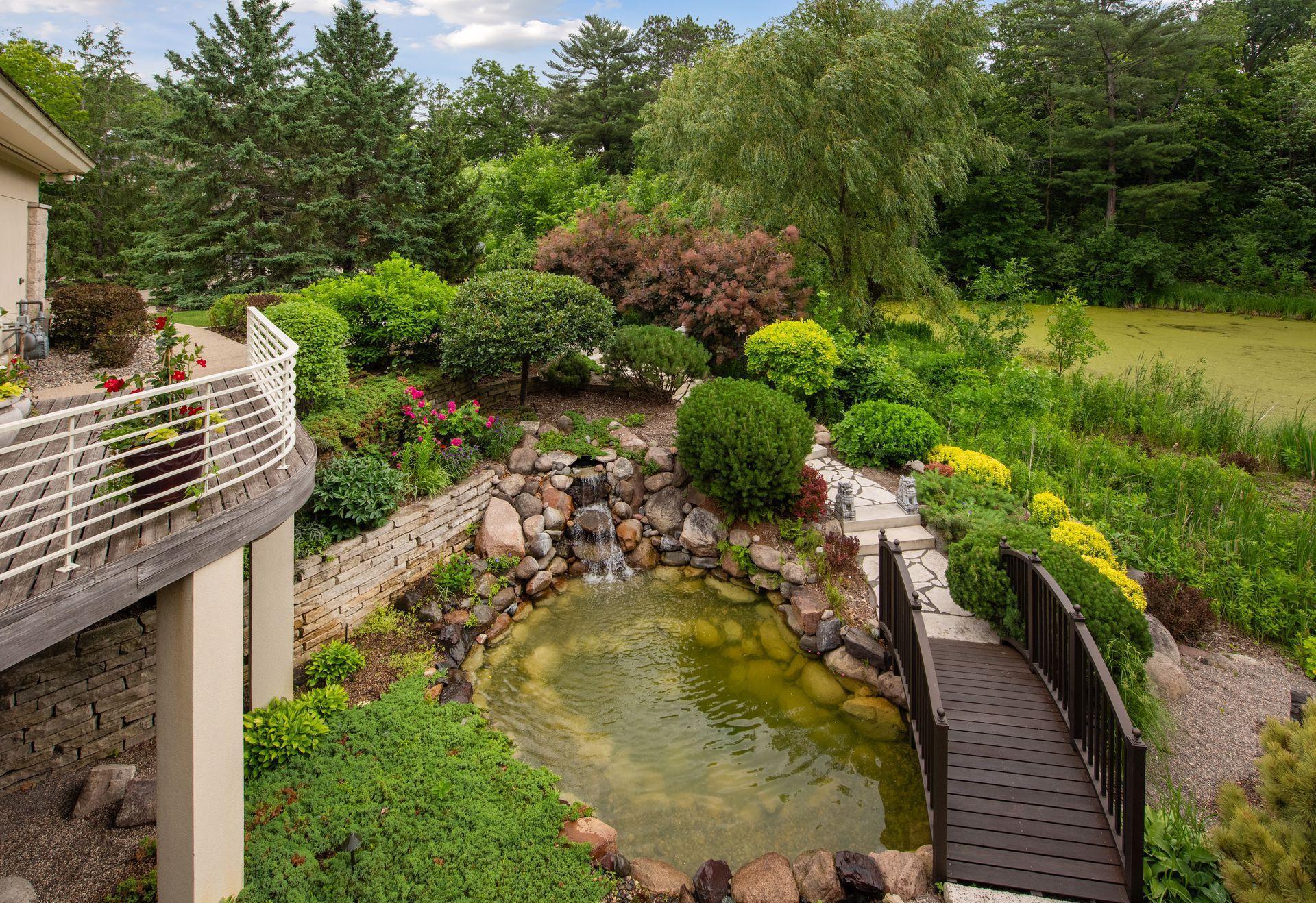 Waterfall pond by walking quaint walking bridge.