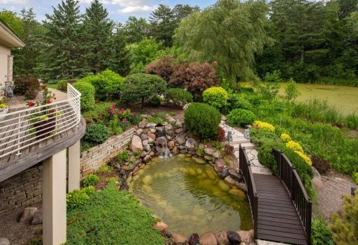 Waterfall pond by walking quaint walking bridge.