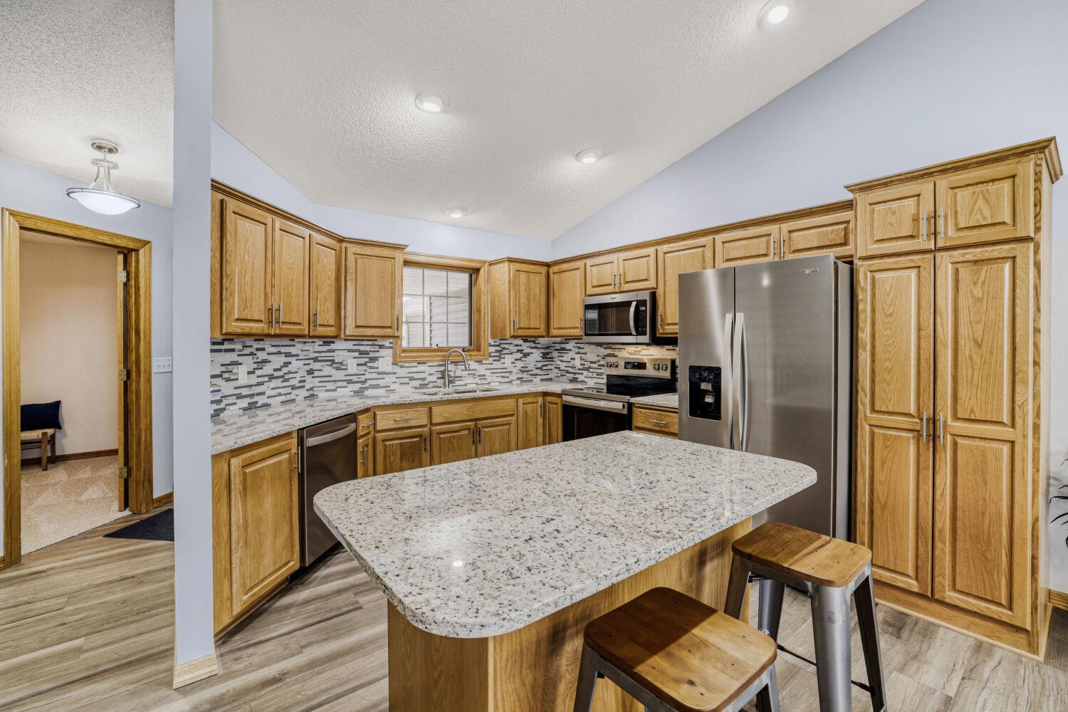 Kitchen includes raised panel cabinets, new granite countertops, new stainless steel appliances, a window over the sink, tiled backsplash, a breakfast bar and lots of storage space for all those small kitchen appliances.