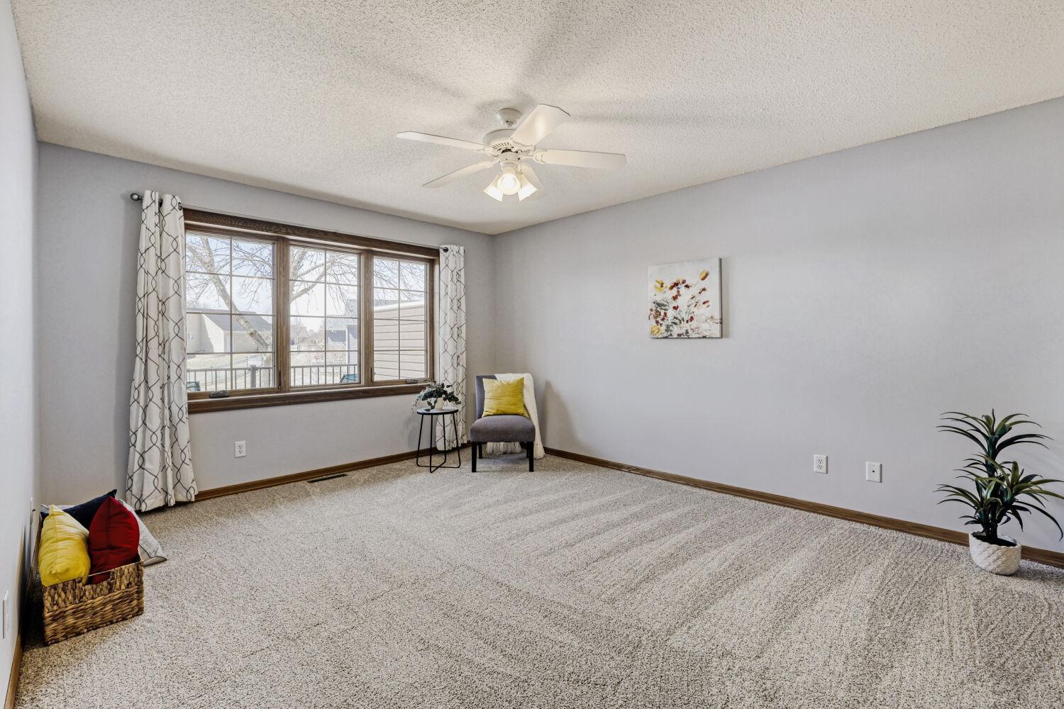 Large beautiful windows in the spacious primary bedroom that look onto the rear deck.