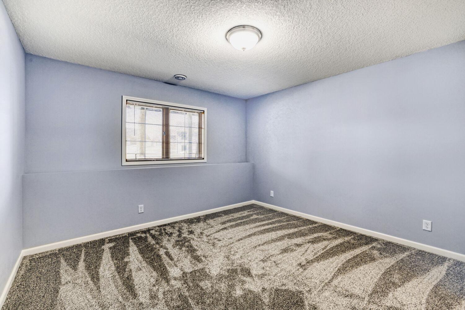 Another view of the lower level bedroom with new flooring. Great natural light from the large windows.