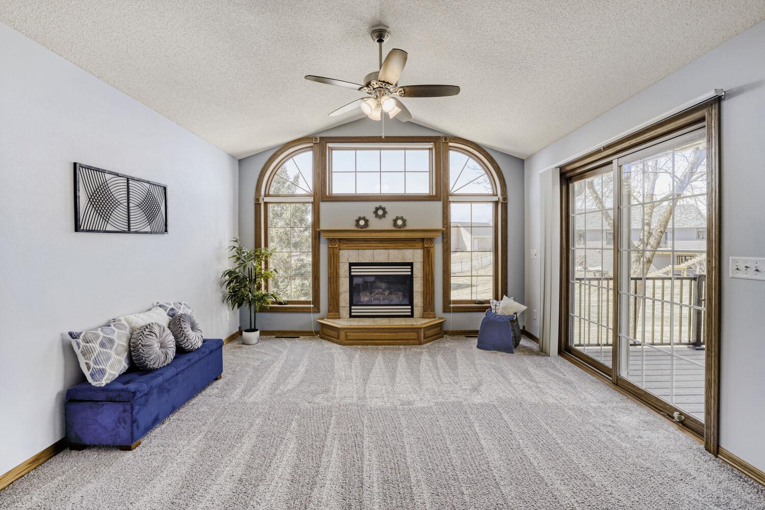 The beautiful windows really accent the fireplace in the living room. The maintenance free deck is located right outside the patio door.