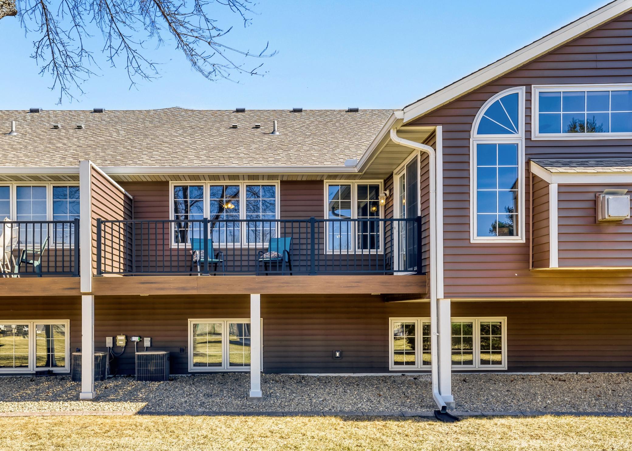 Rear view of the home showing the upper level and lower level windows and deck. Notice the privacy wall between residences.