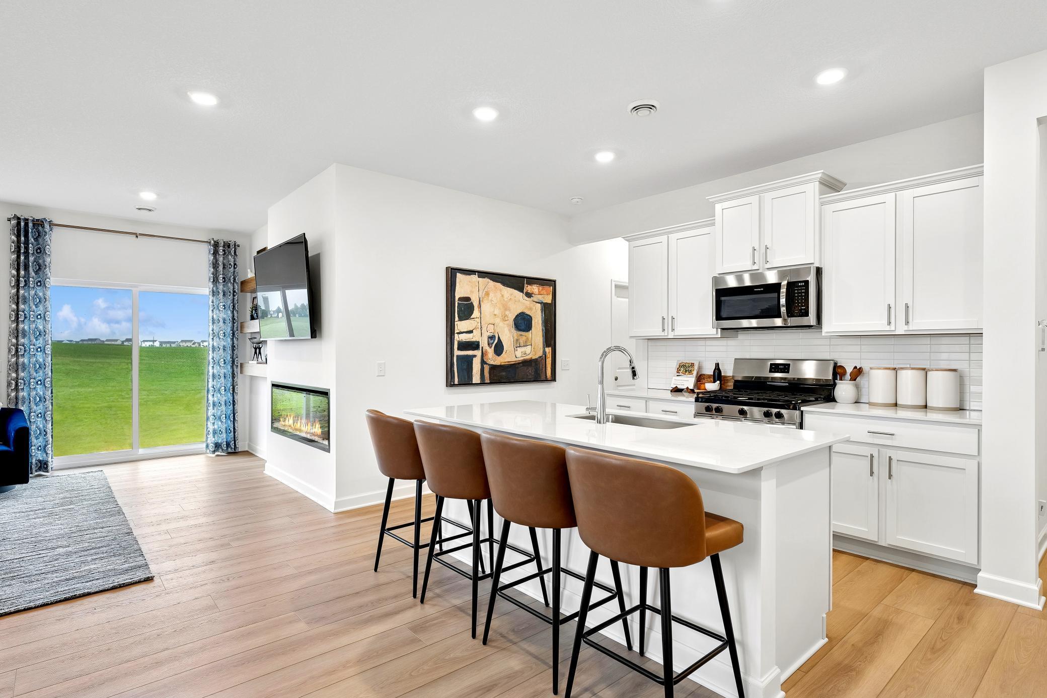 (Photo of a decorated model, actual homes finishes will vary) An open concept design allows the kitchen to flow seamlessly into the dining room, making multitasking simple!