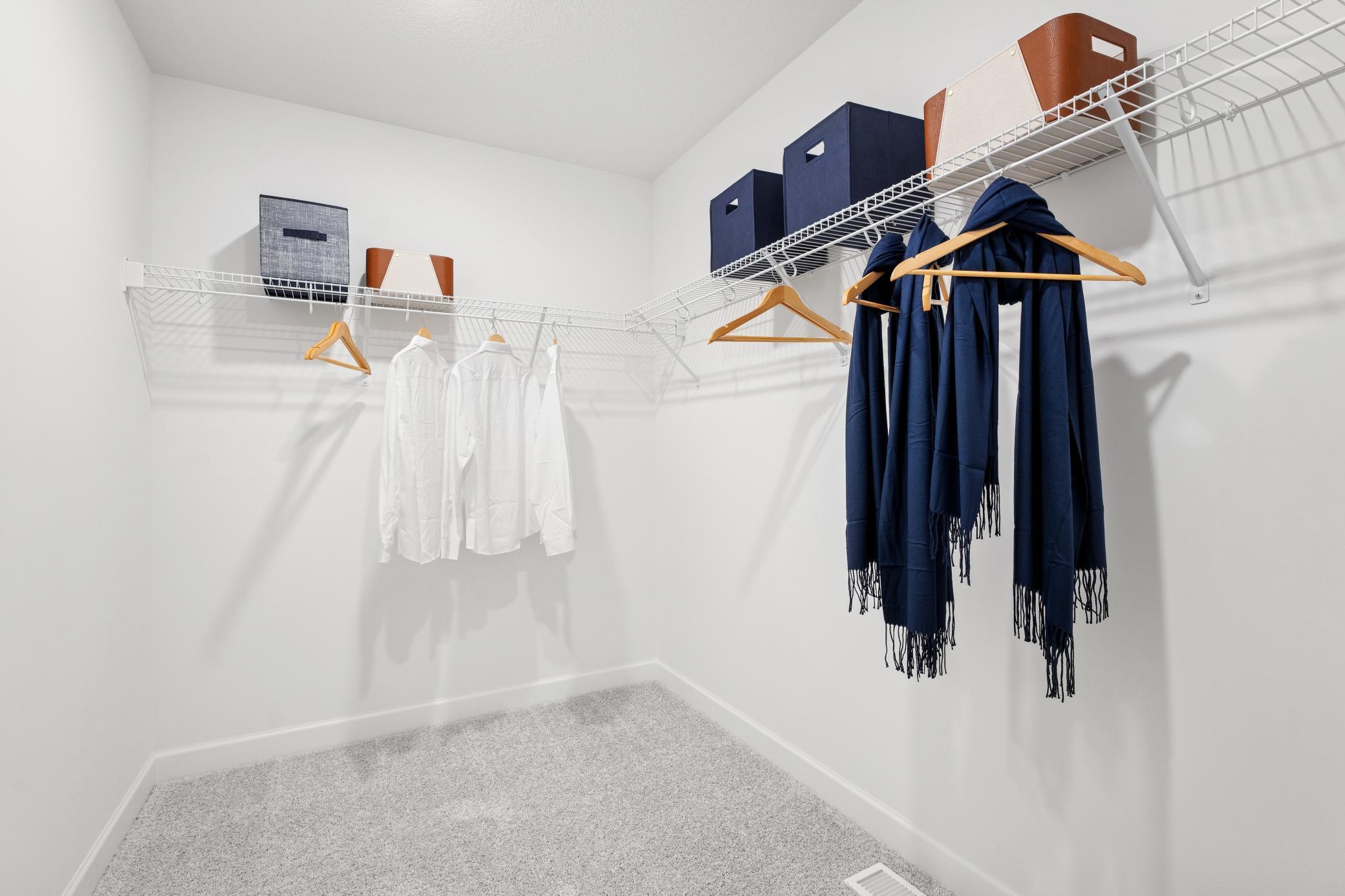 (Photo of a decorated model, actual homes finishes will vary) The primary bedroom's walk-in closet.