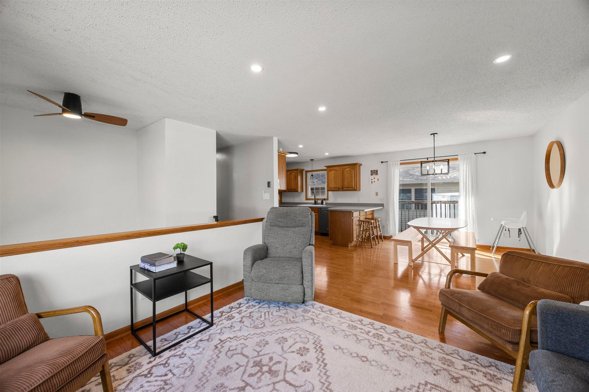 The upper level feels bright and welcoming, with great natural light and a comfortable flow between the living and dining spaces. Wood flooring runs throughout, adding warmth and character.