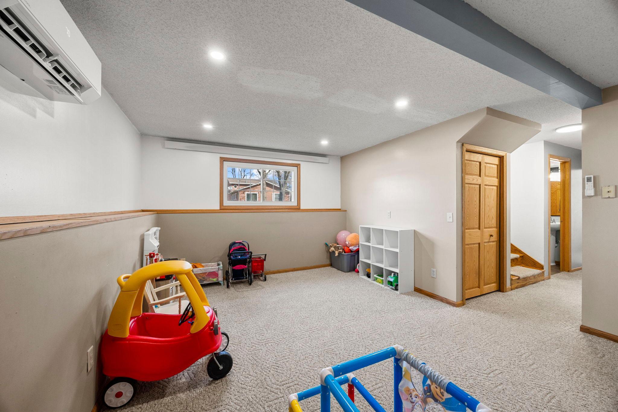 Downstairs, the lower level opens to a spacious rec room with comfortable carpeting and plenty of natural light.