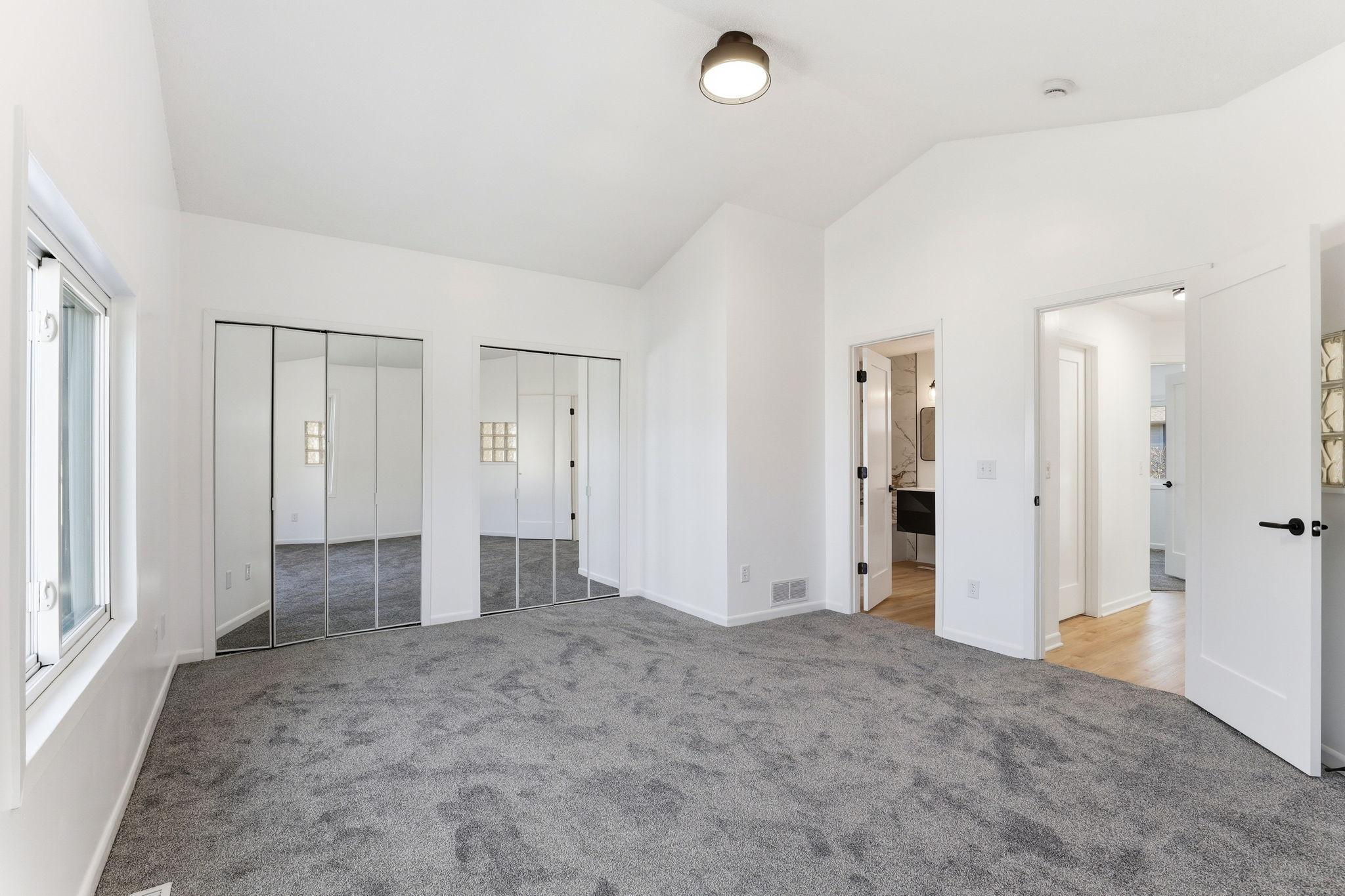 Spacious primary bedroom featuring a private door connecting directly to the full bathroom