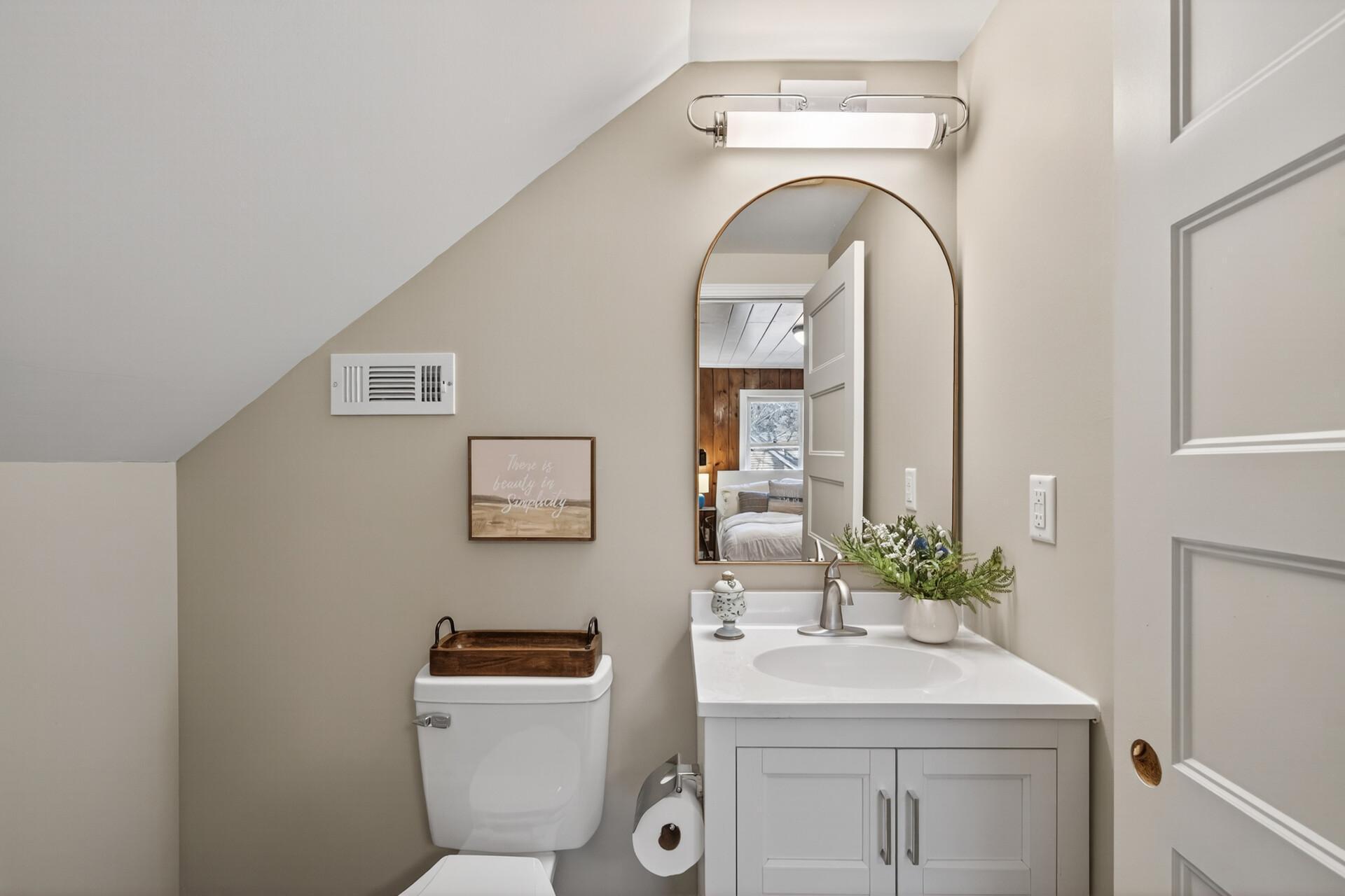 Another stunning space featuring a crisp white vanity and modern hardware.
