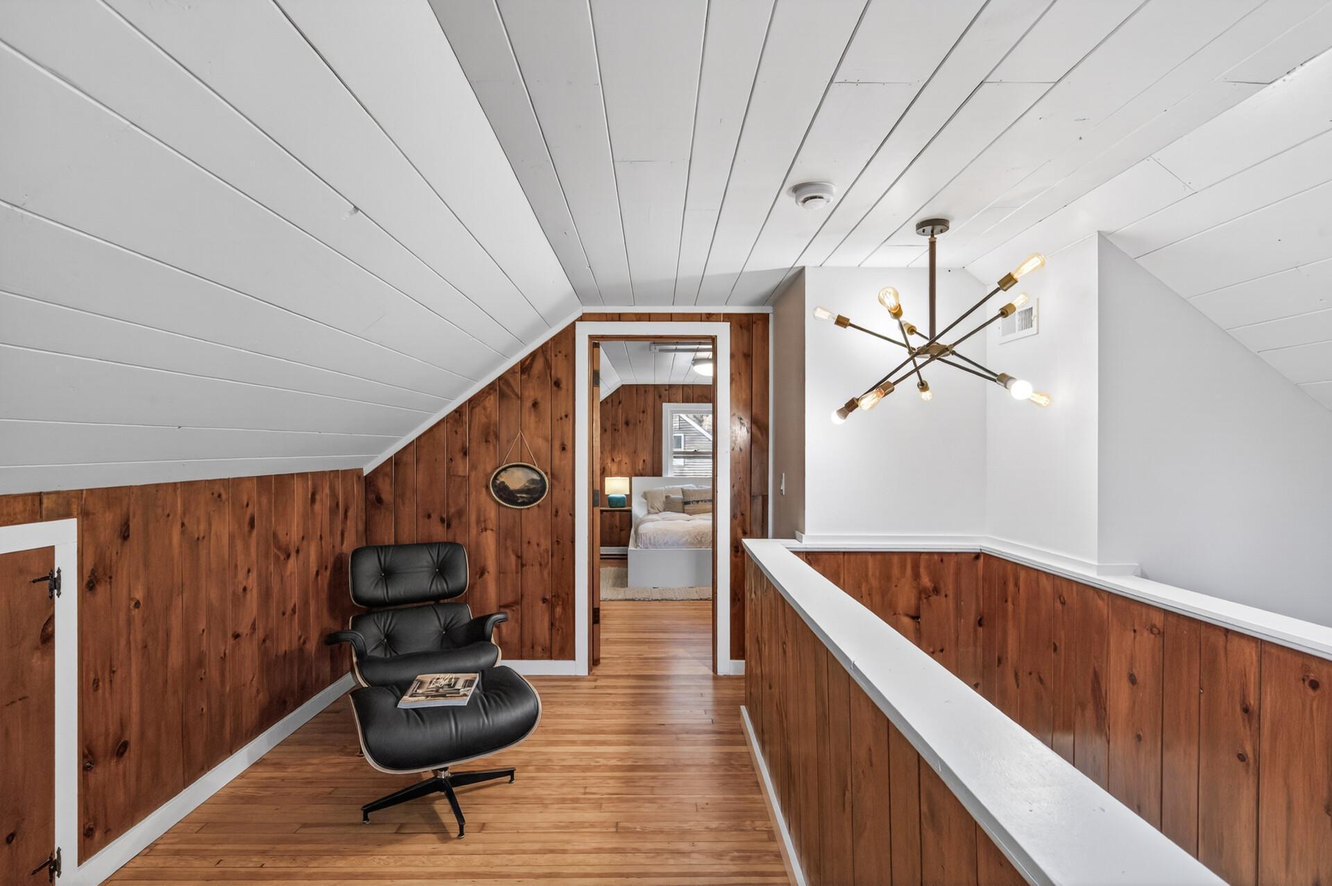 Upstairs, the loft offers a private primary retreat with warm wood accents and modern lighting.