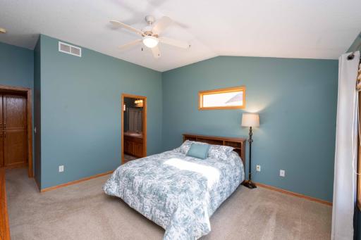 Featuring plush carpeting, vaulted ceilings, and a ceiling fan.