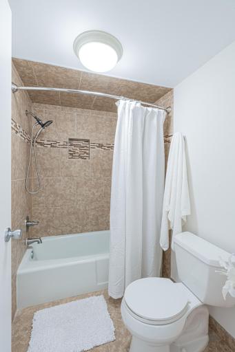 4548 Cedar Lake Rd S _ Full bath within primary bedroom has tiled floors and tiled surround.