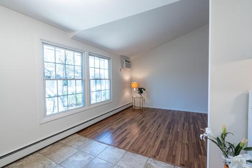 4548 Cedar Lake Rd S _ Bright living room with large windows and warm wood-style floors.