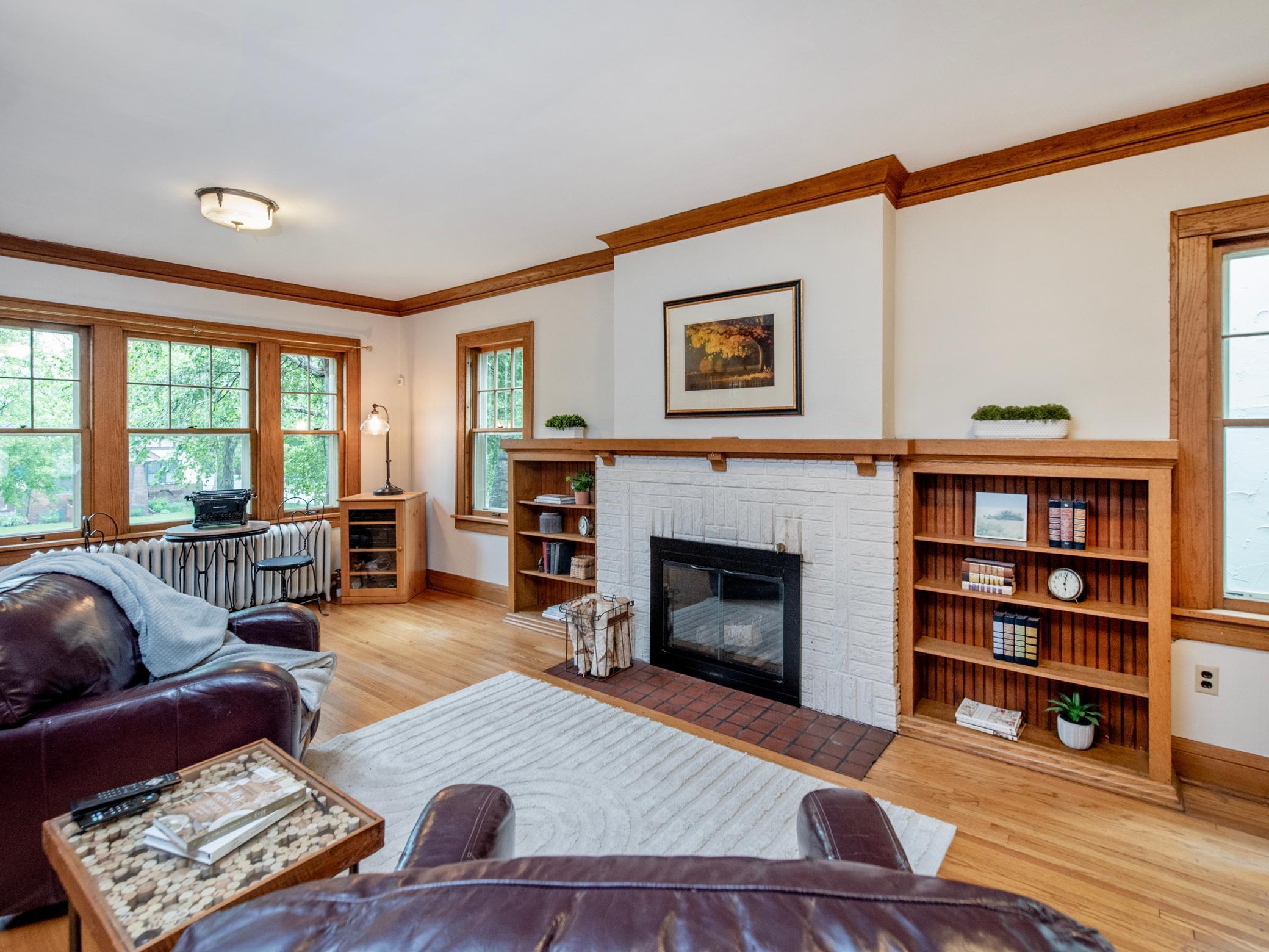 Warm front living space with original hardwood floors and a charming fireplace centerpiece with built-ins.