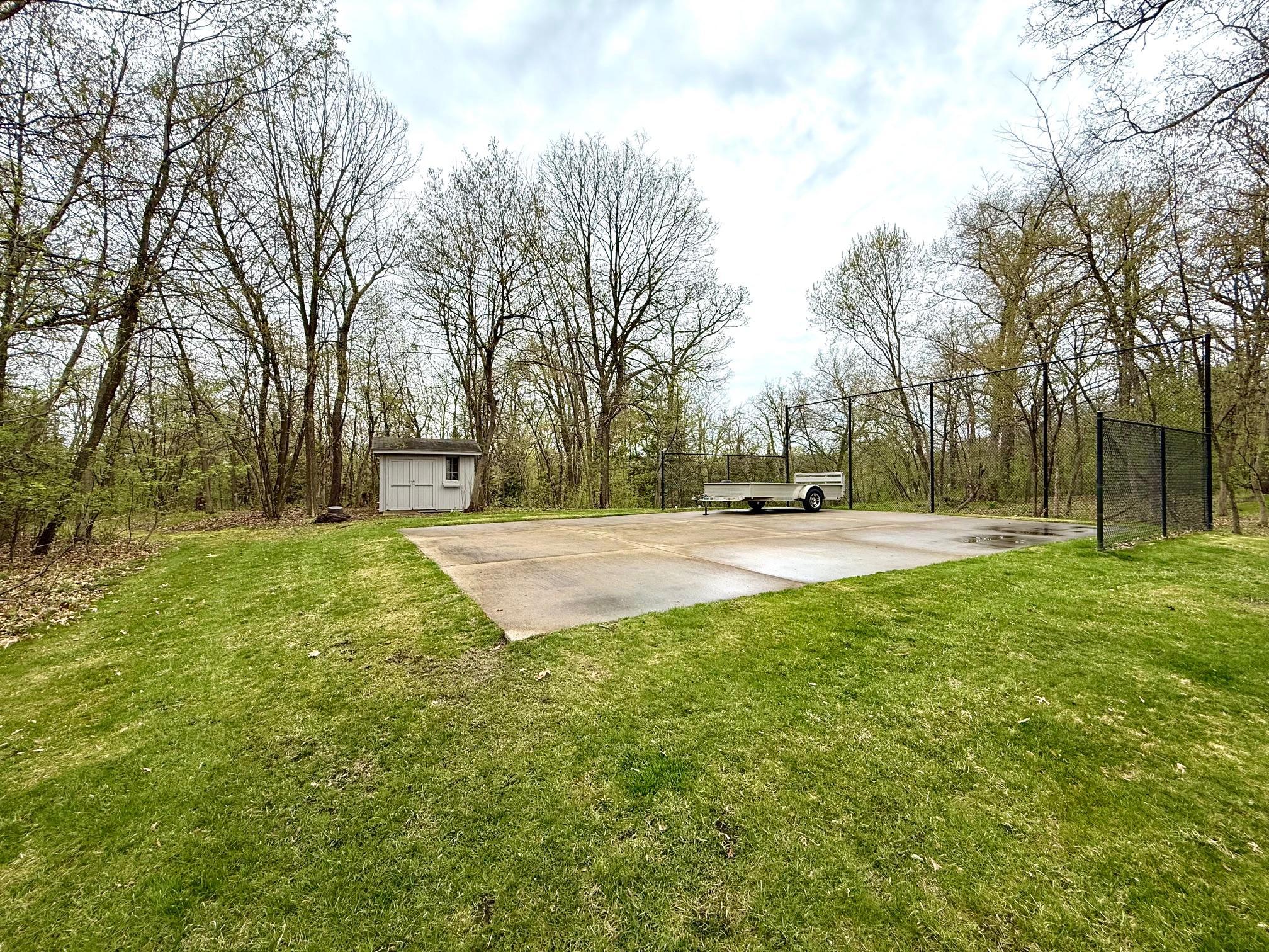 Fabulous backyard features a basketball court, which could also serve as foundation for outbuilding, etc.