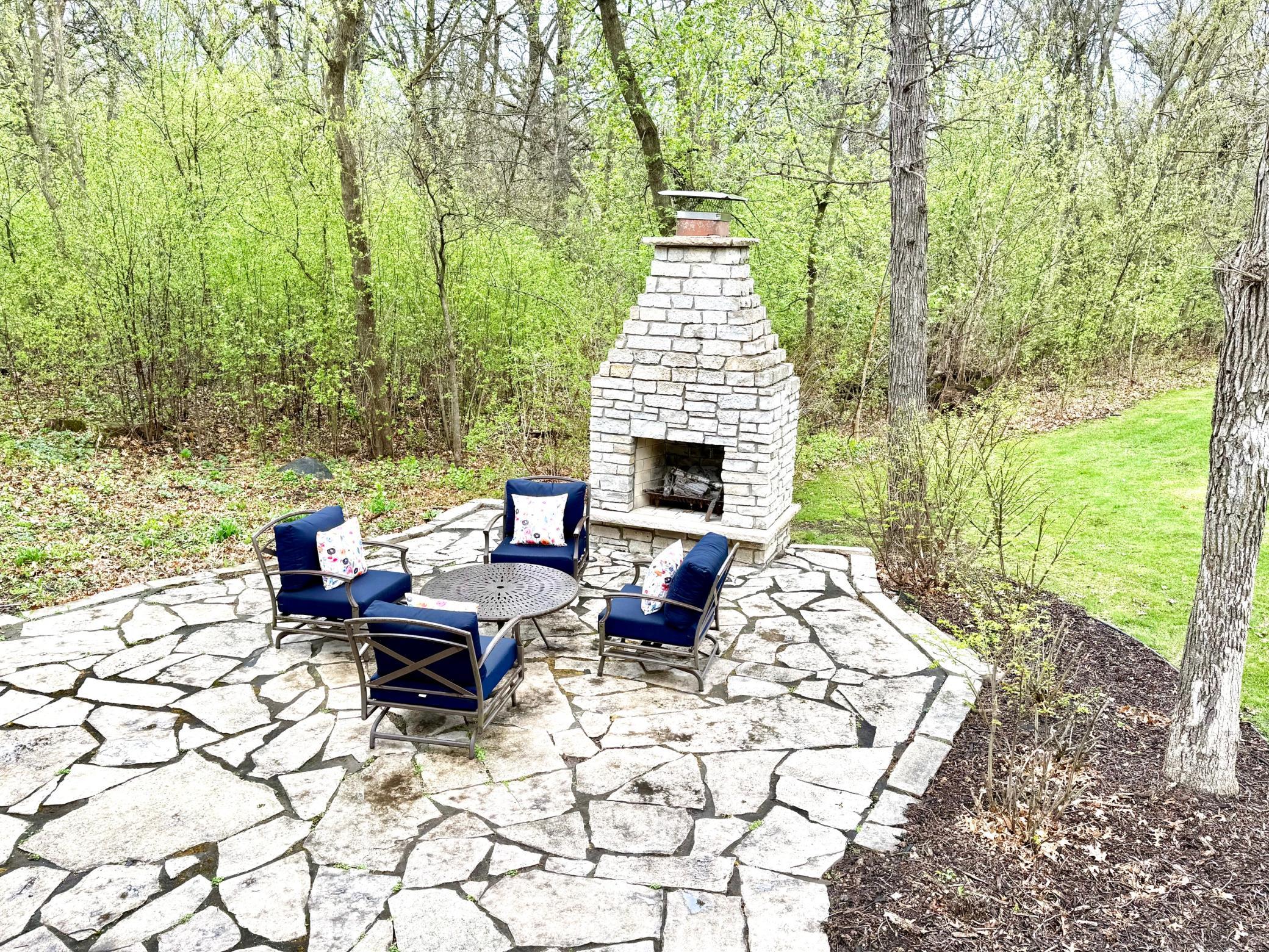 Patio in the backyard with fireplace that has a great space for seating options. Sit and enjoy the views!