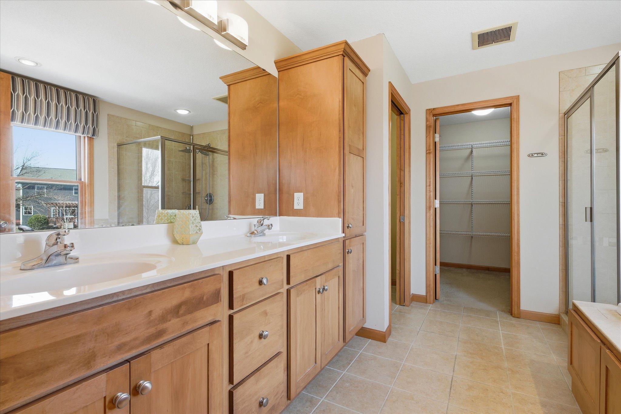 Spacious primary ensuite bathroom offers double-sink, commode room, walk-in closet and more...
