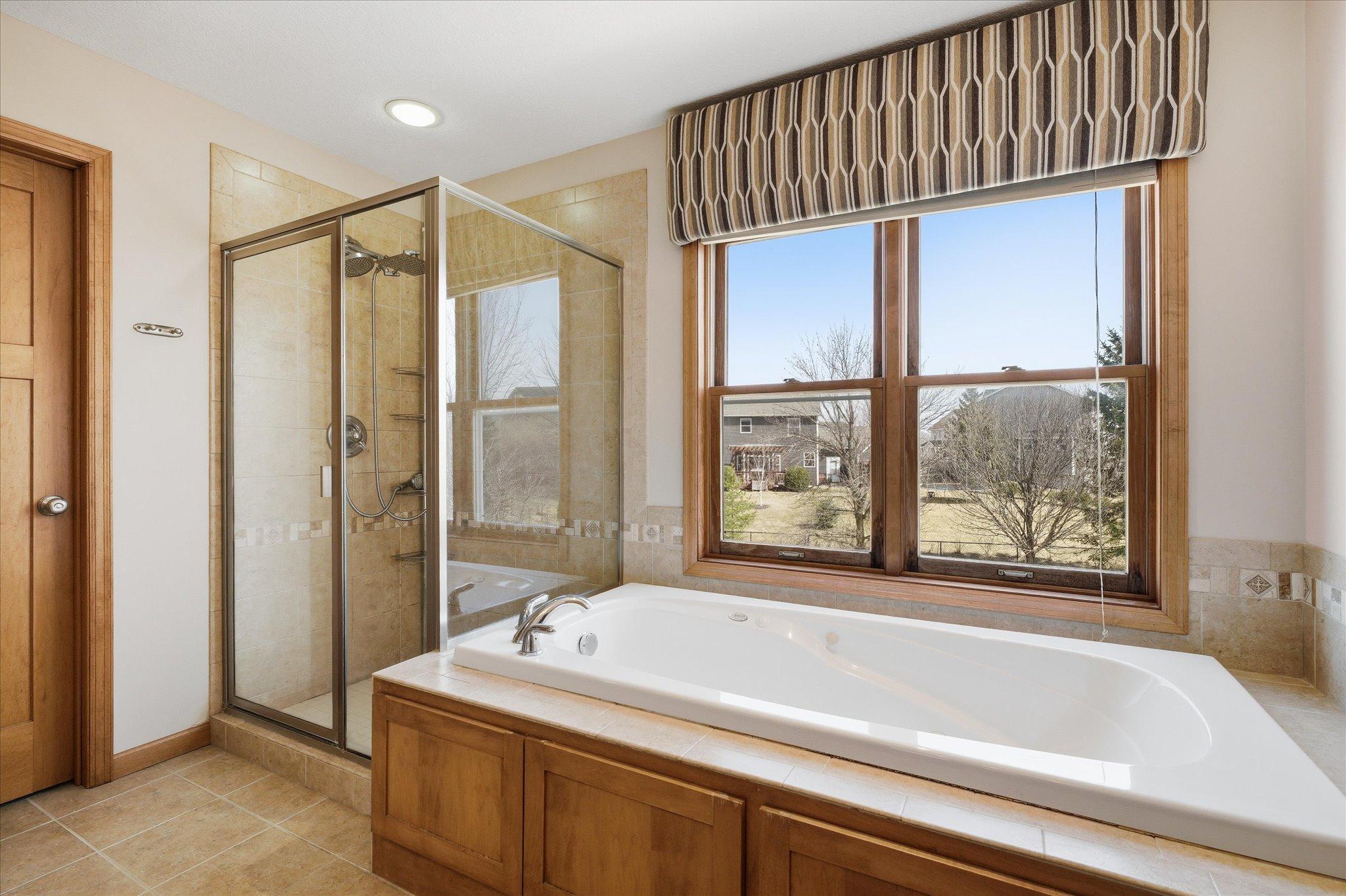 ... separate glass shower and jetted tub enjoying the view of the back yard.