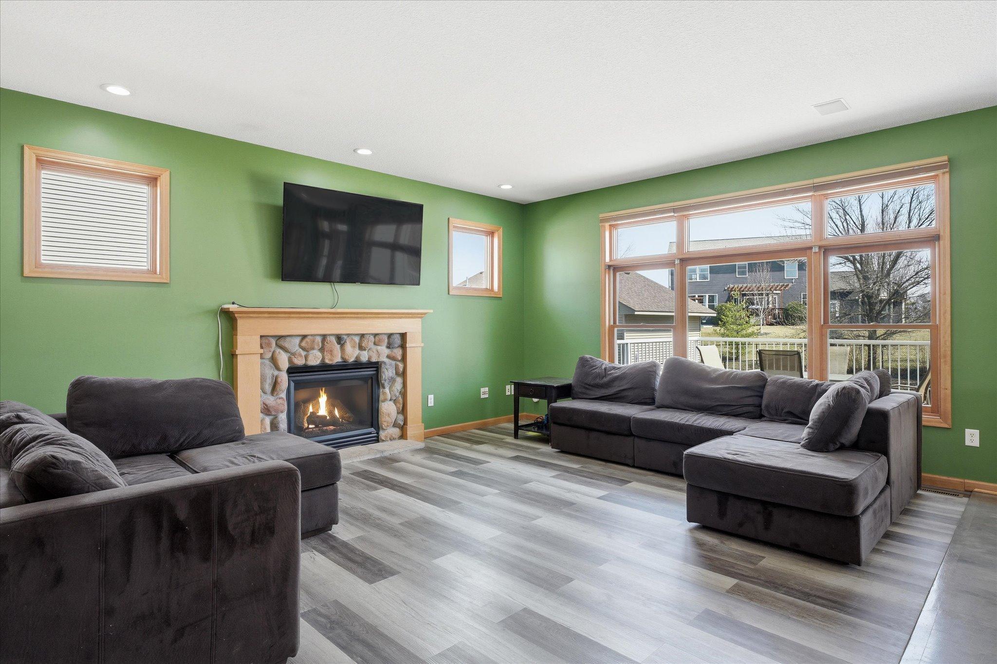 Light-filled Living Room focuses on the gas fireplace and open windows to enjoy the outdoors.