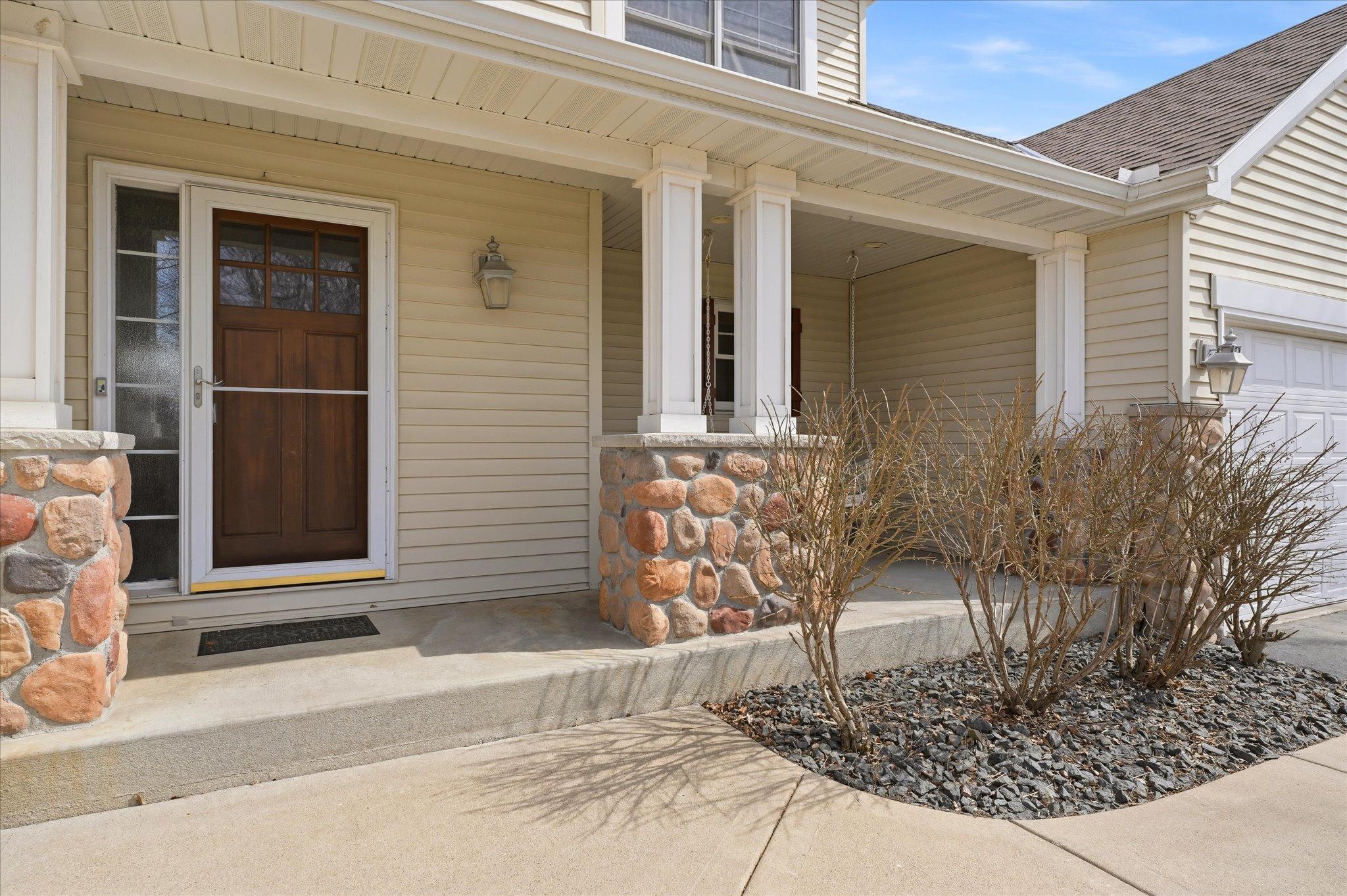There is a cute front-porch swing hiding behind that post and bush.