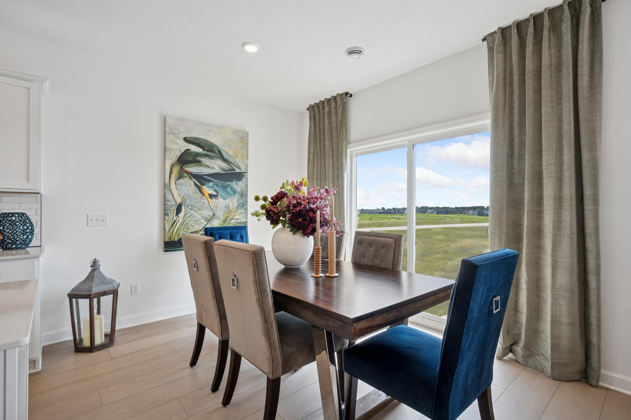 (Photo of a decorated model, actual homes finishes will vary) Soaked in natural sunlight, the home's eat-in dining room has ample space for a dining table located in the heart of the home.