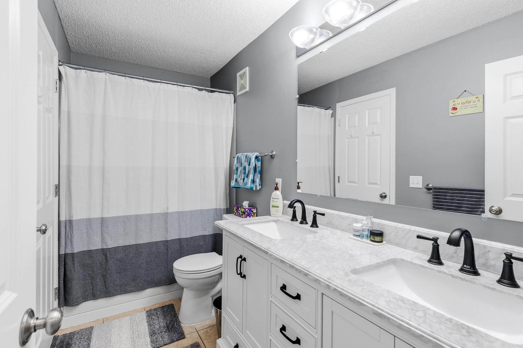 An ensuite bathroom with a new vanity with double sinks.