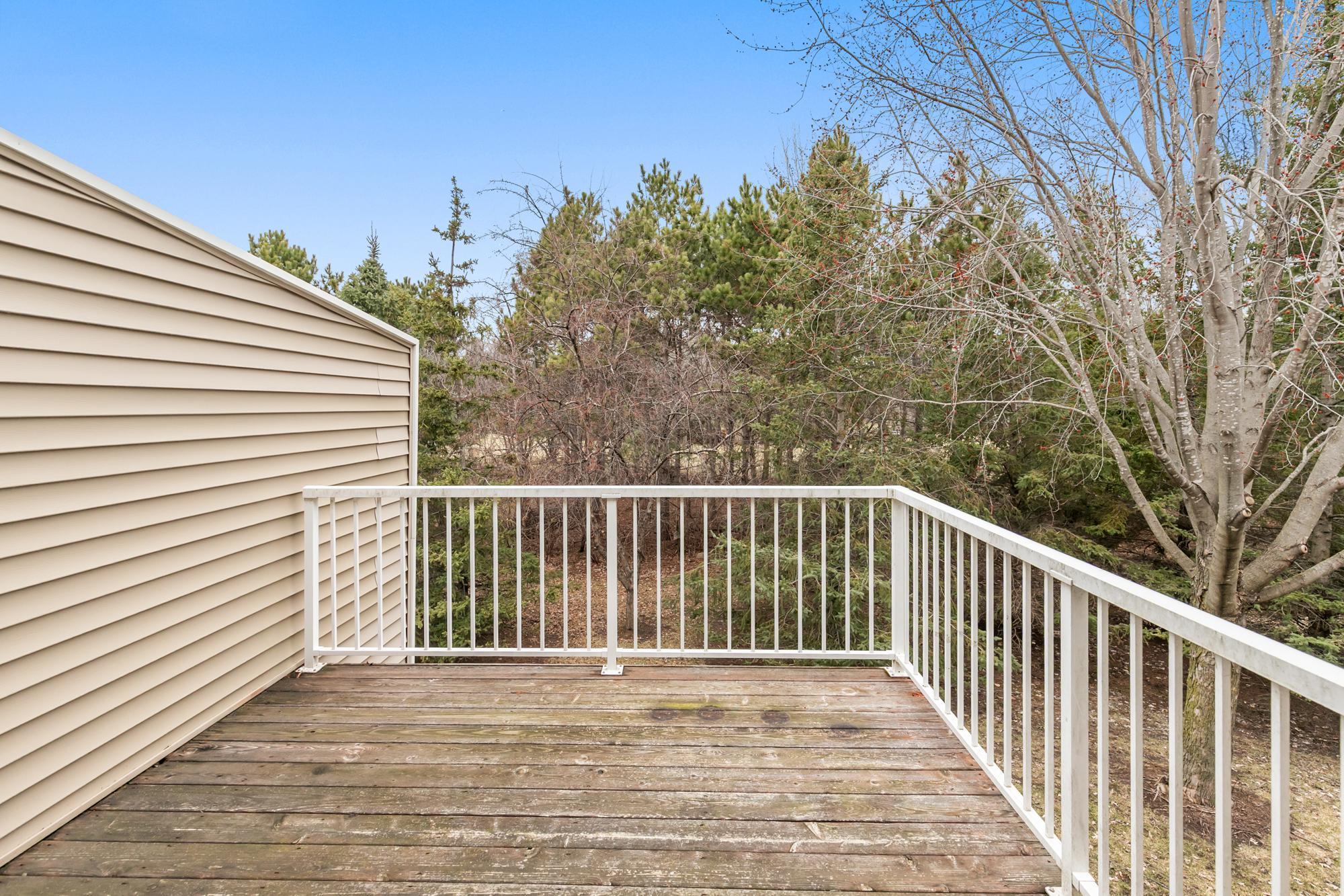 The deck overlooks a private yard.