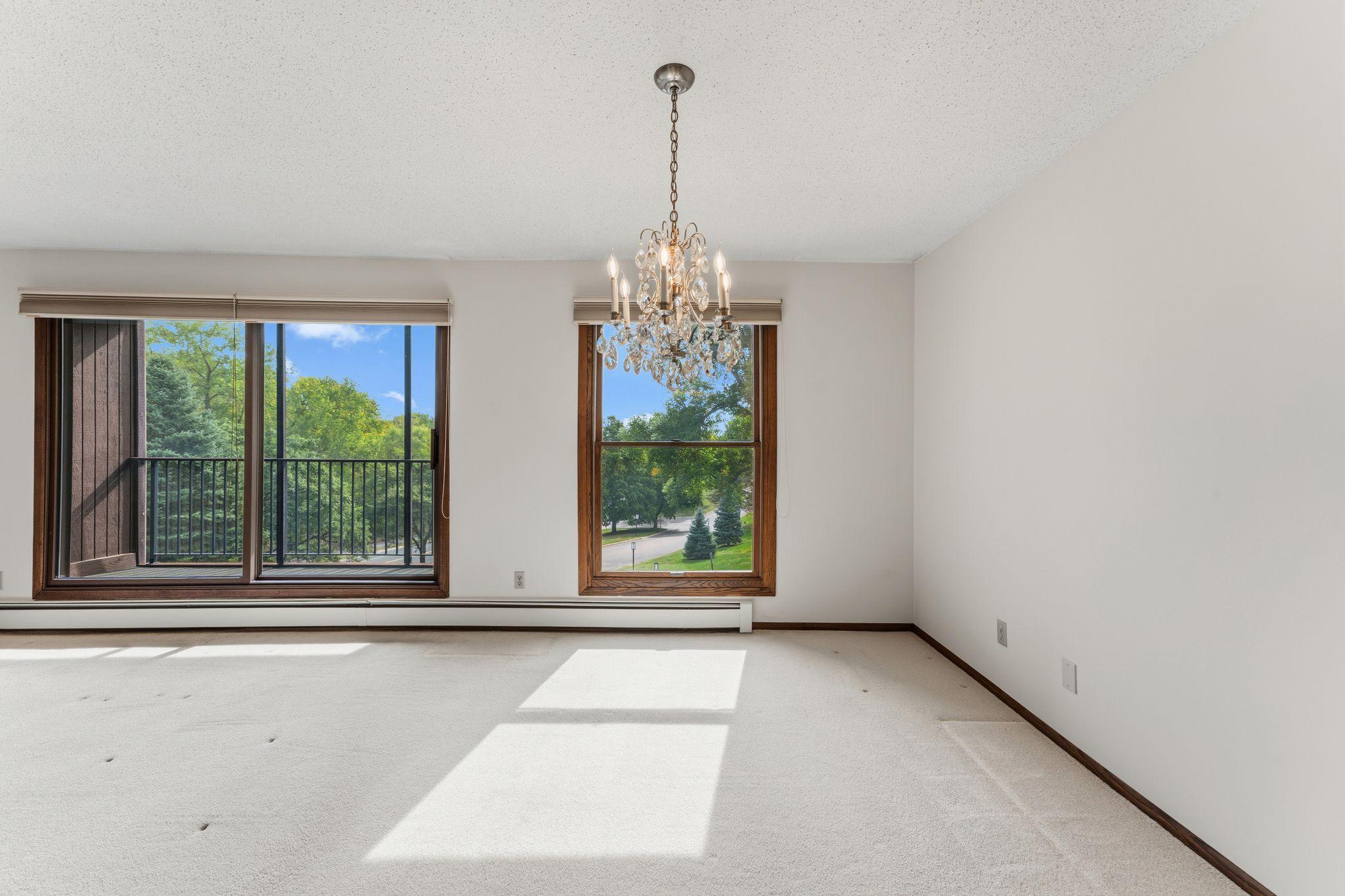 The dining room features a large window and chandelier