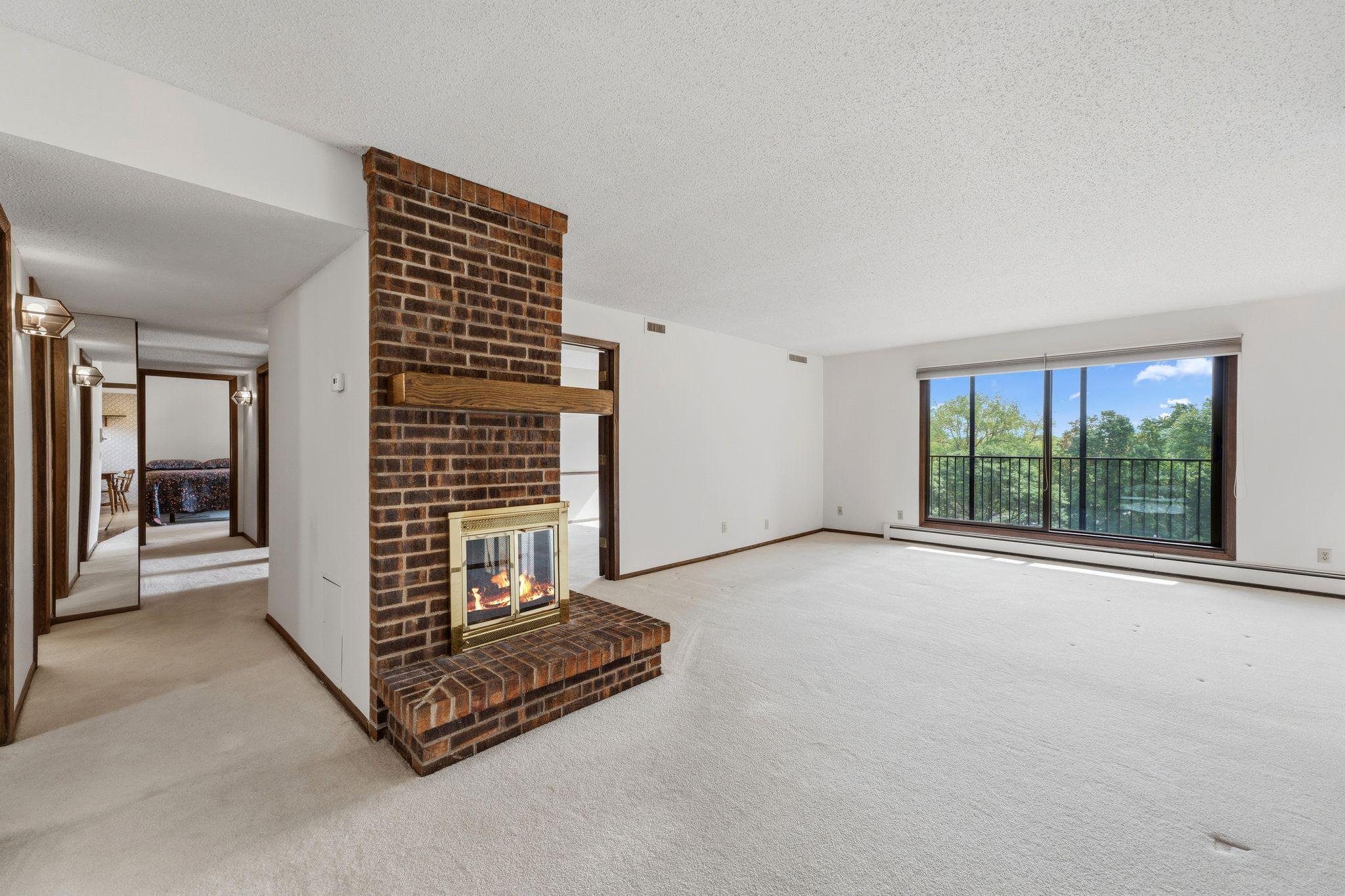 The large living room features two-sided fireplace and steps onto the screened porch