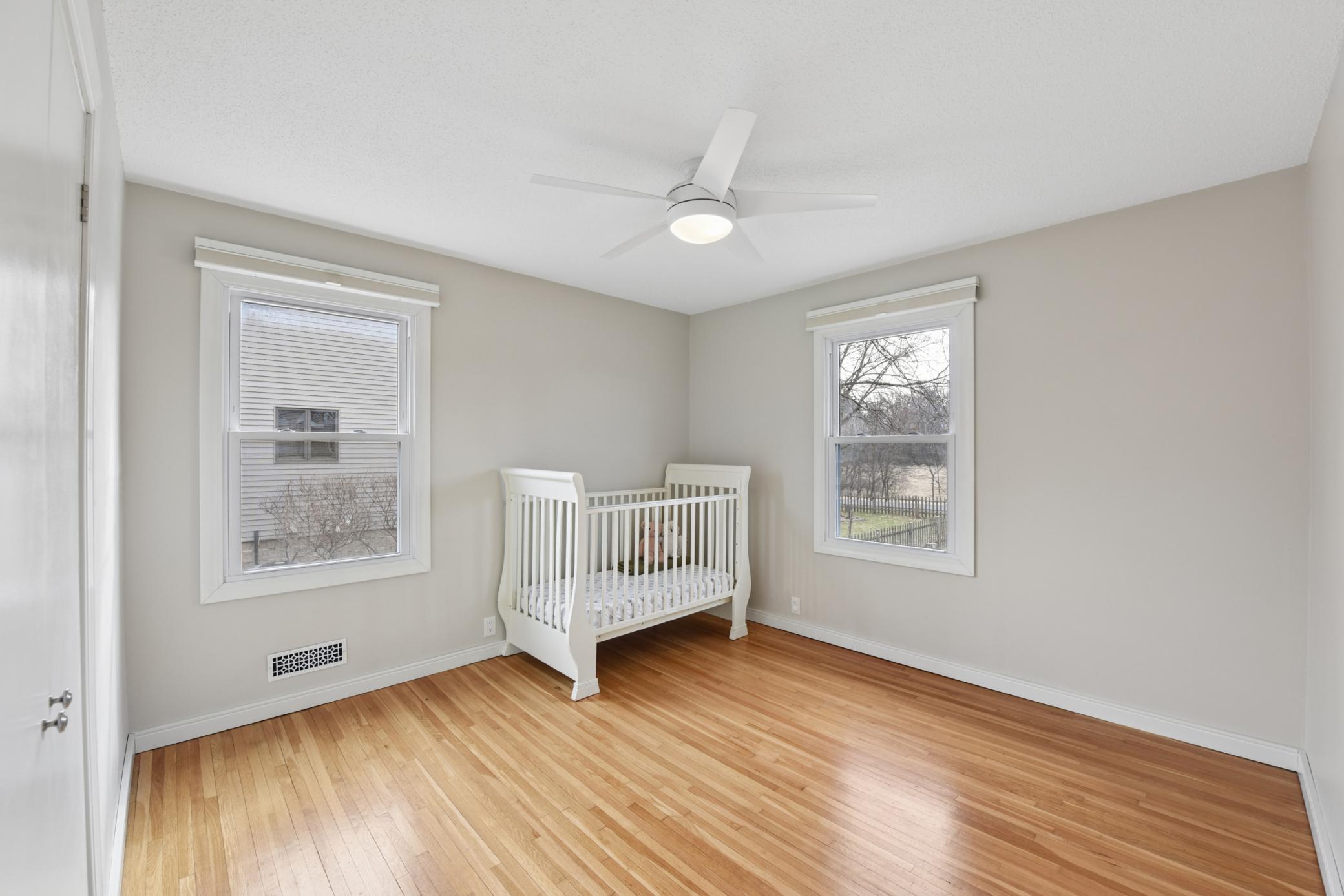 The second main floor bedroom with continued hardwood flooring and closet built-ins.