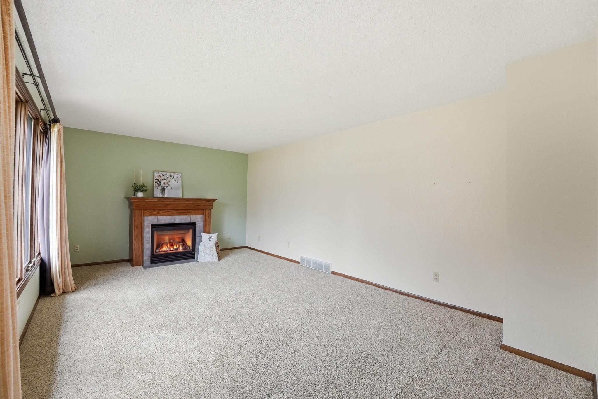 Large living room with gas fireplace and ample natural light.