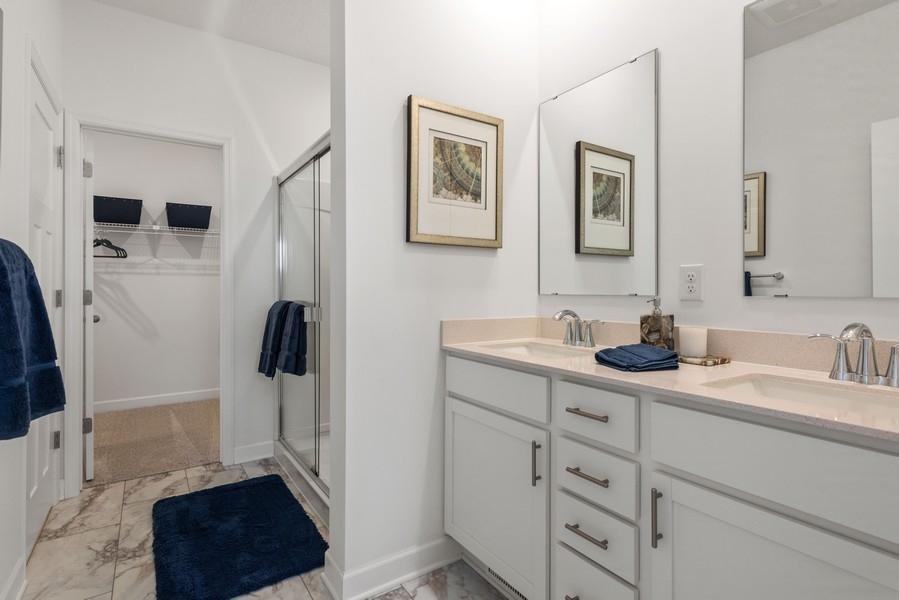 (Photo of a decorated model, actual homes finishes will vary) An extension of the primary bedroom, this bath includes a double-vanity, shower and access to the walk-in closet.