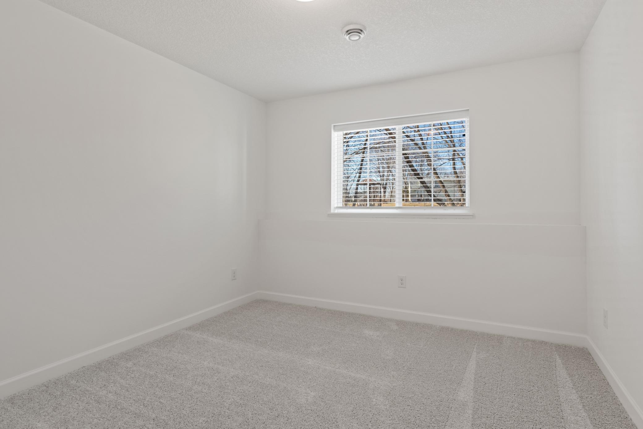 (Photo of a decorated model, actual homes finishes will vary) Lower level bed.