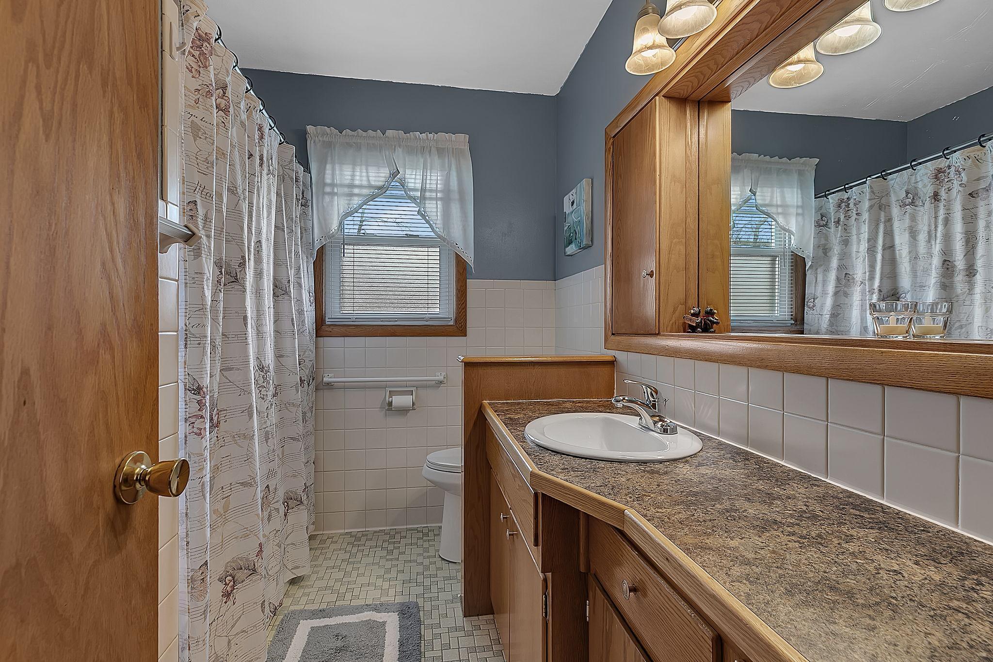 Full upper level shared bathroom with a large vanity.