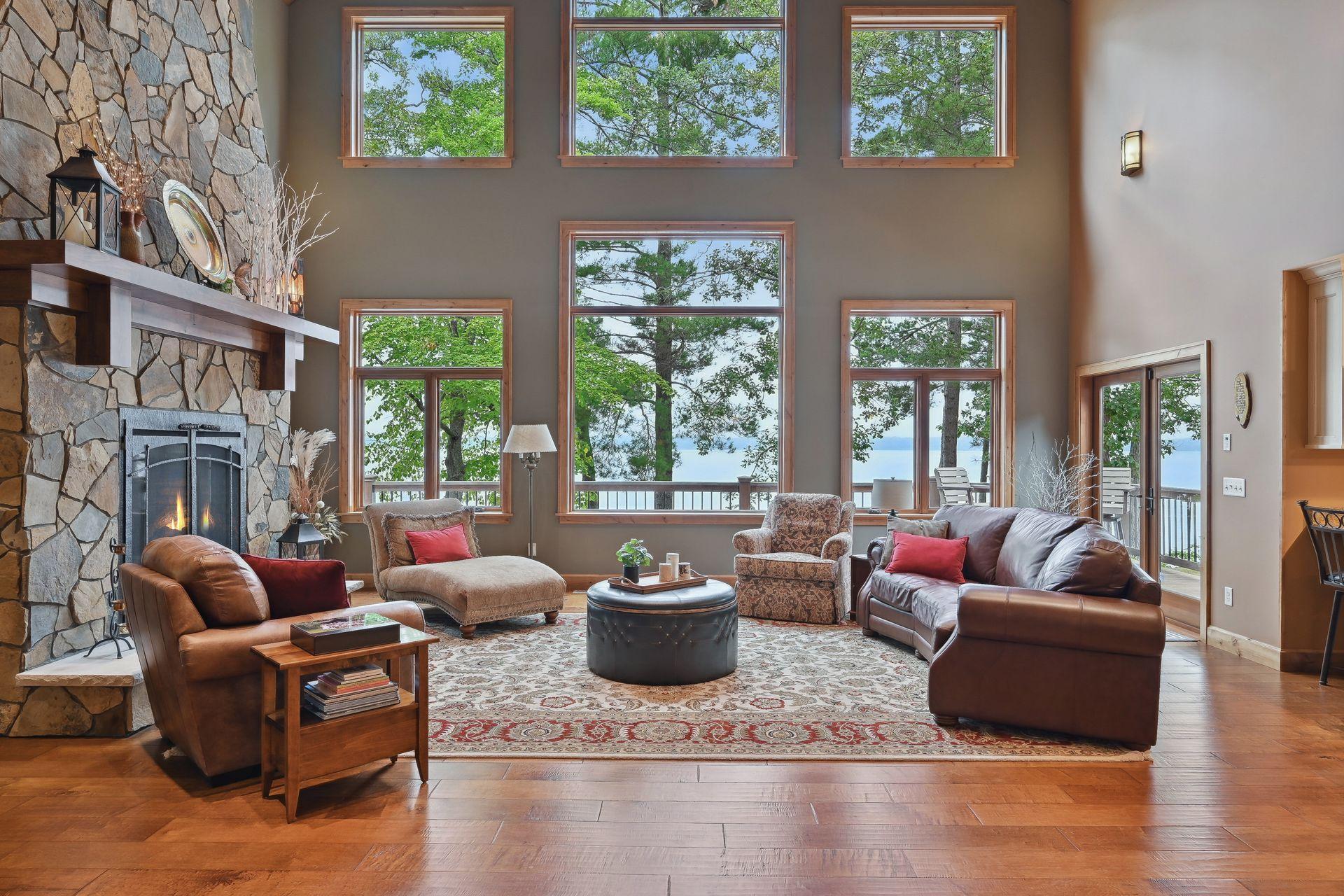 Soaring wall of windows brings the outdoors in while the stacked stone fireplace keeps things cozy