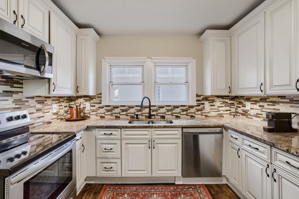 Enjoy this beautiful and functional kitchen with granite counters tile backsplash and stunning cabinetry!