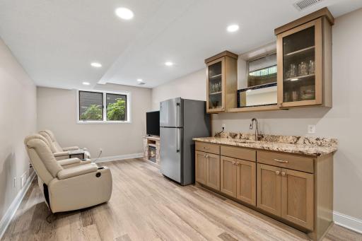 A custom wet bar with granite countertops anchors the room and keeps refreshments close at hand.