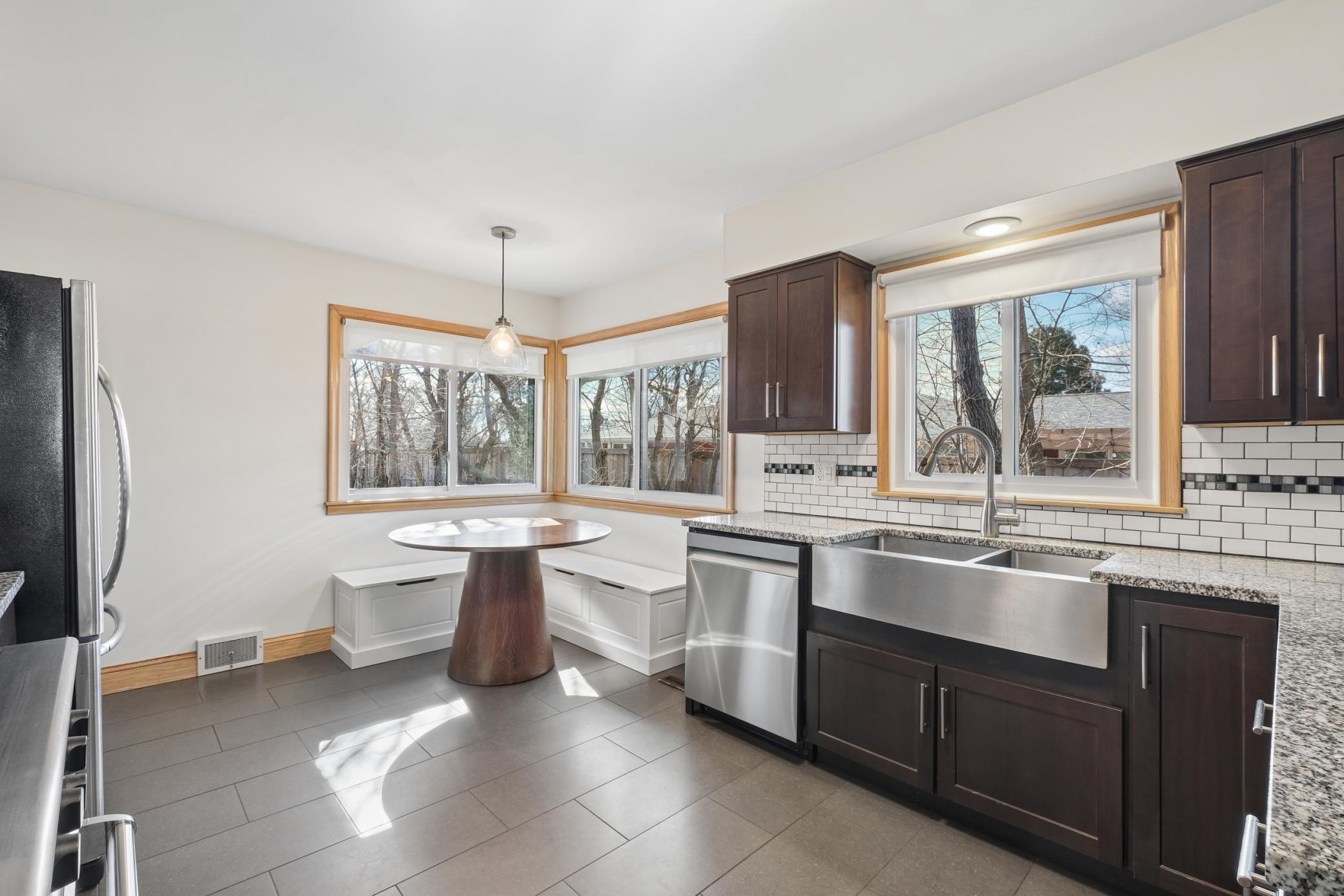 The kitchen is flooded with natural light, and features a quaint breakfast nook