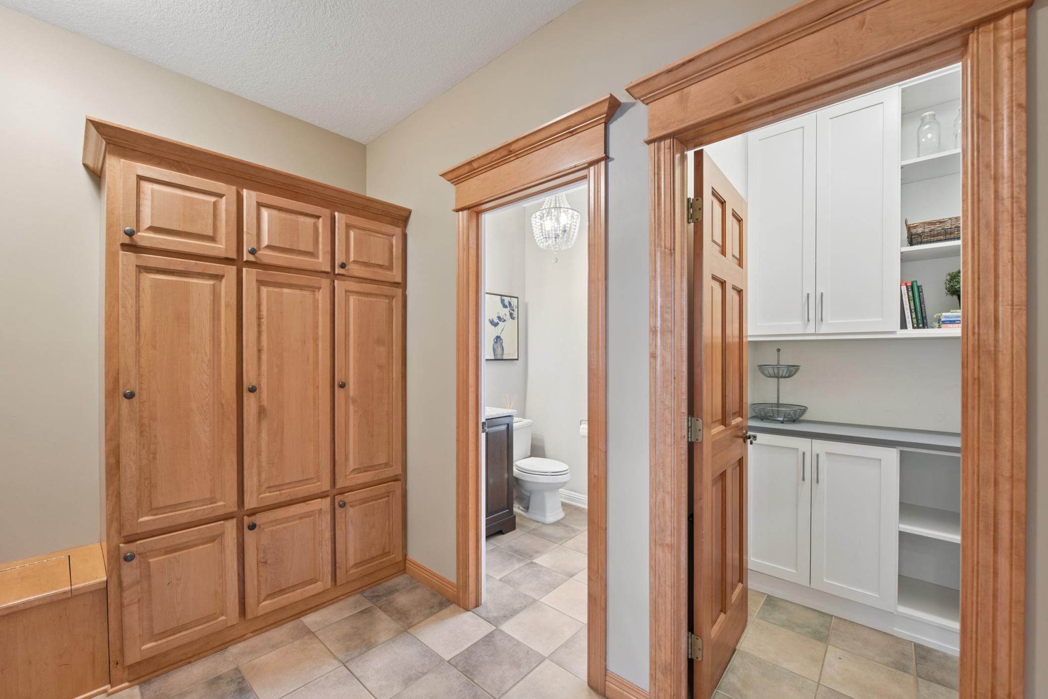 Spacious mudroom opens to powder bath and walk in pantry