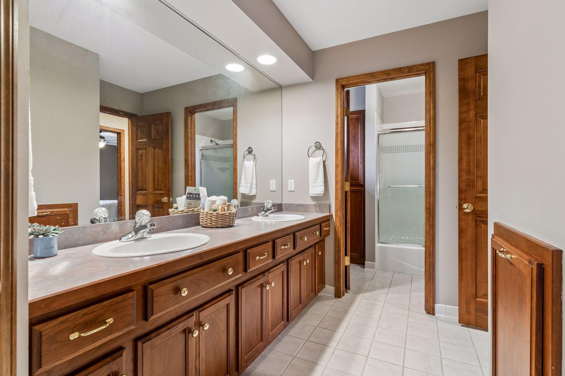 Upper level full bath complete with dual sinks, abundant cabinetry and a separate water closet with bathtub within.