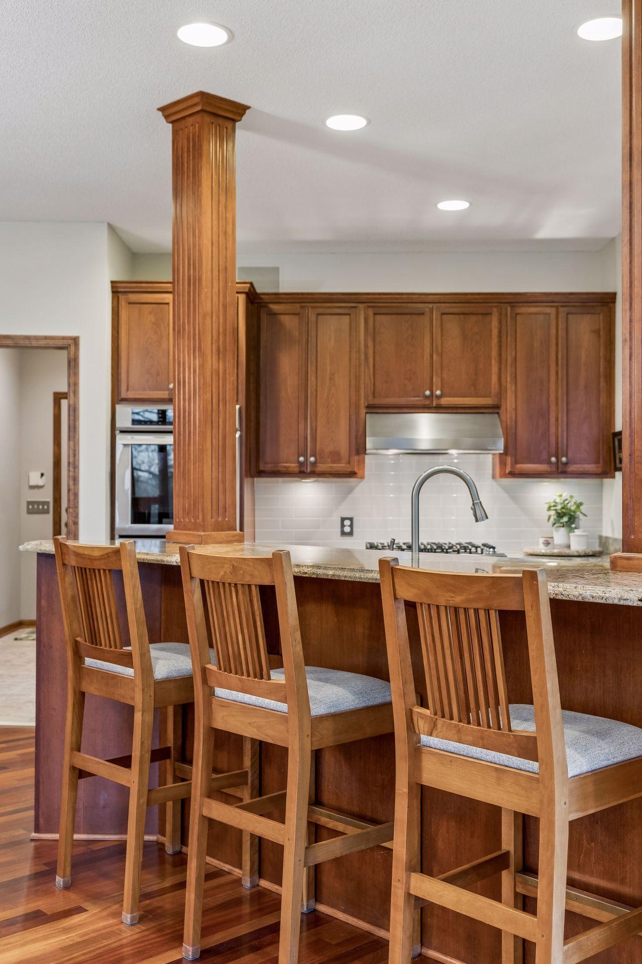 Fluted columns accent the raised breakfast bar with comfortable seating for three.