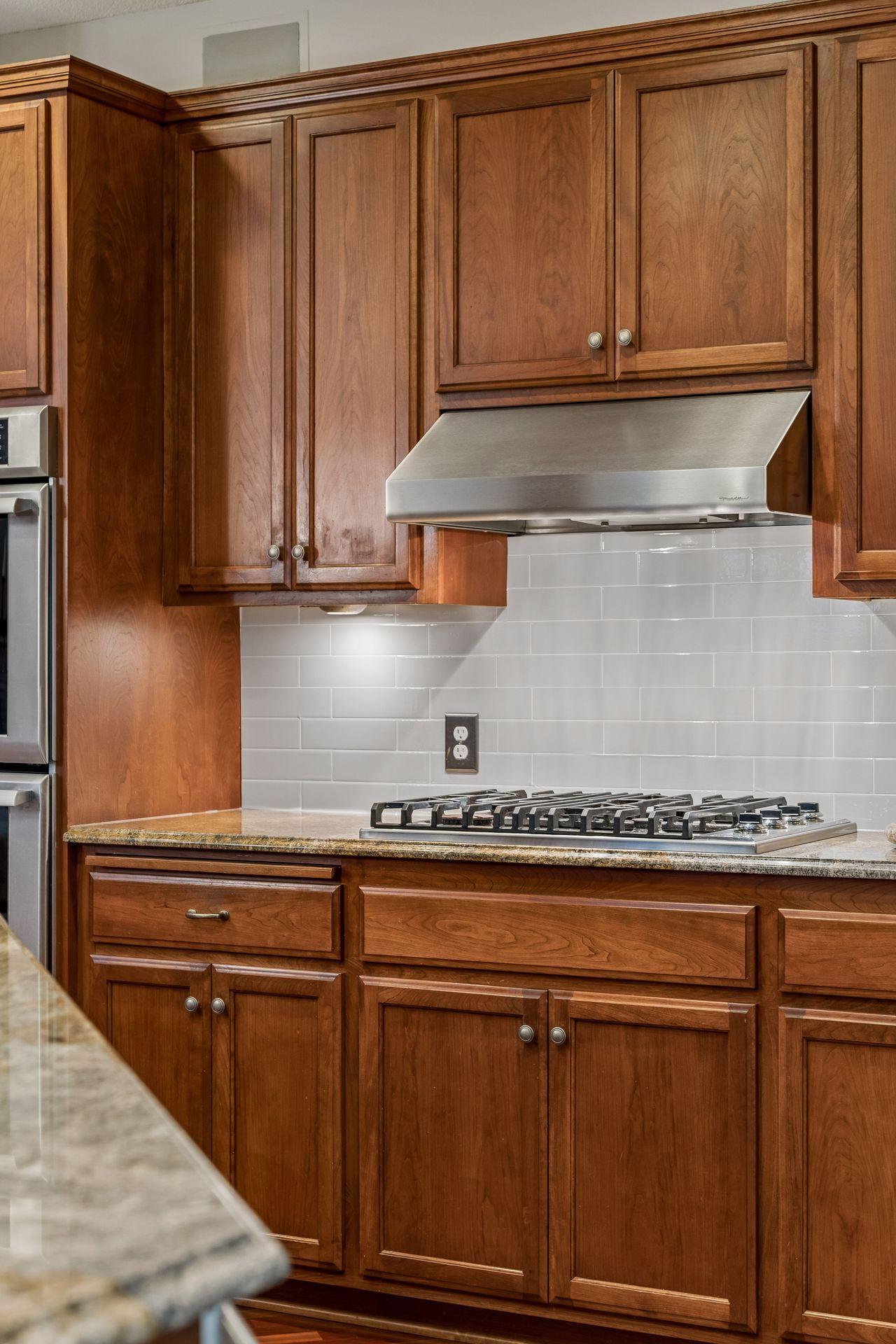 Elegant granite counter tops with a decorative tile backsplash to compliment.