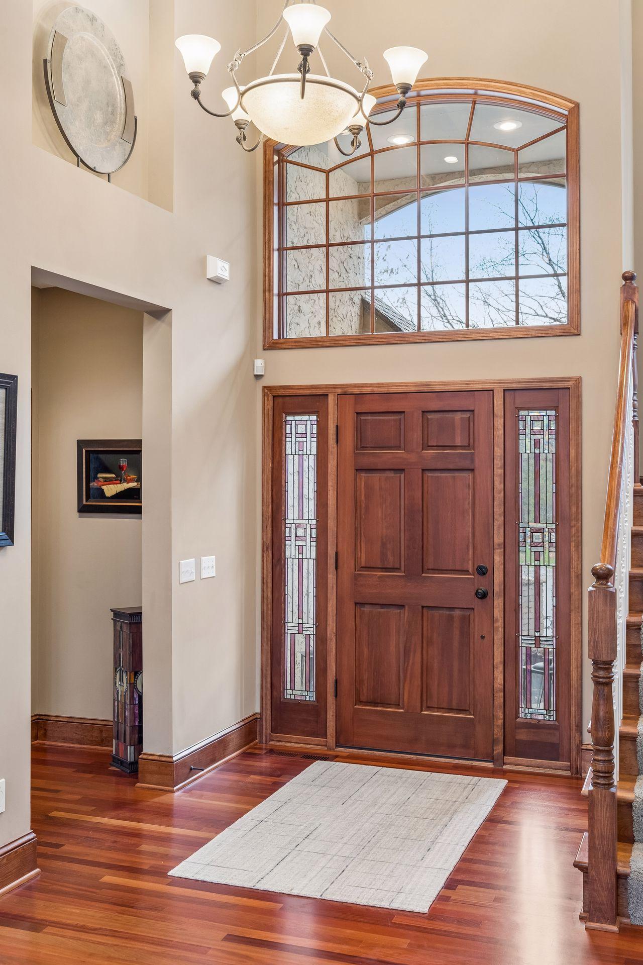 Grand foyer entrance with an elegant art niche, chandelier, gleaming hardwood floor and a convenient guest coat closet nearby.