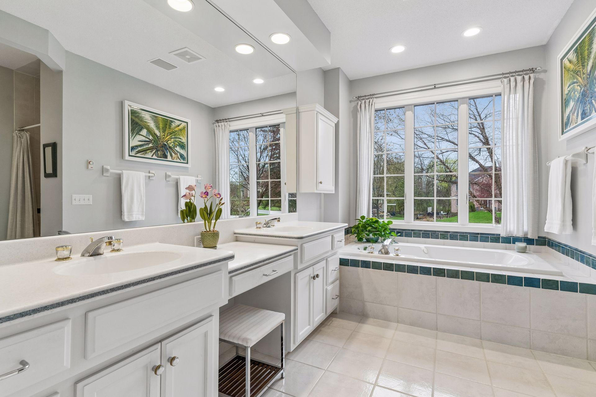 Sparkling primary bath with a heated tile floor, dual sinks, separate whirlpool bath and custom walk-in shower.