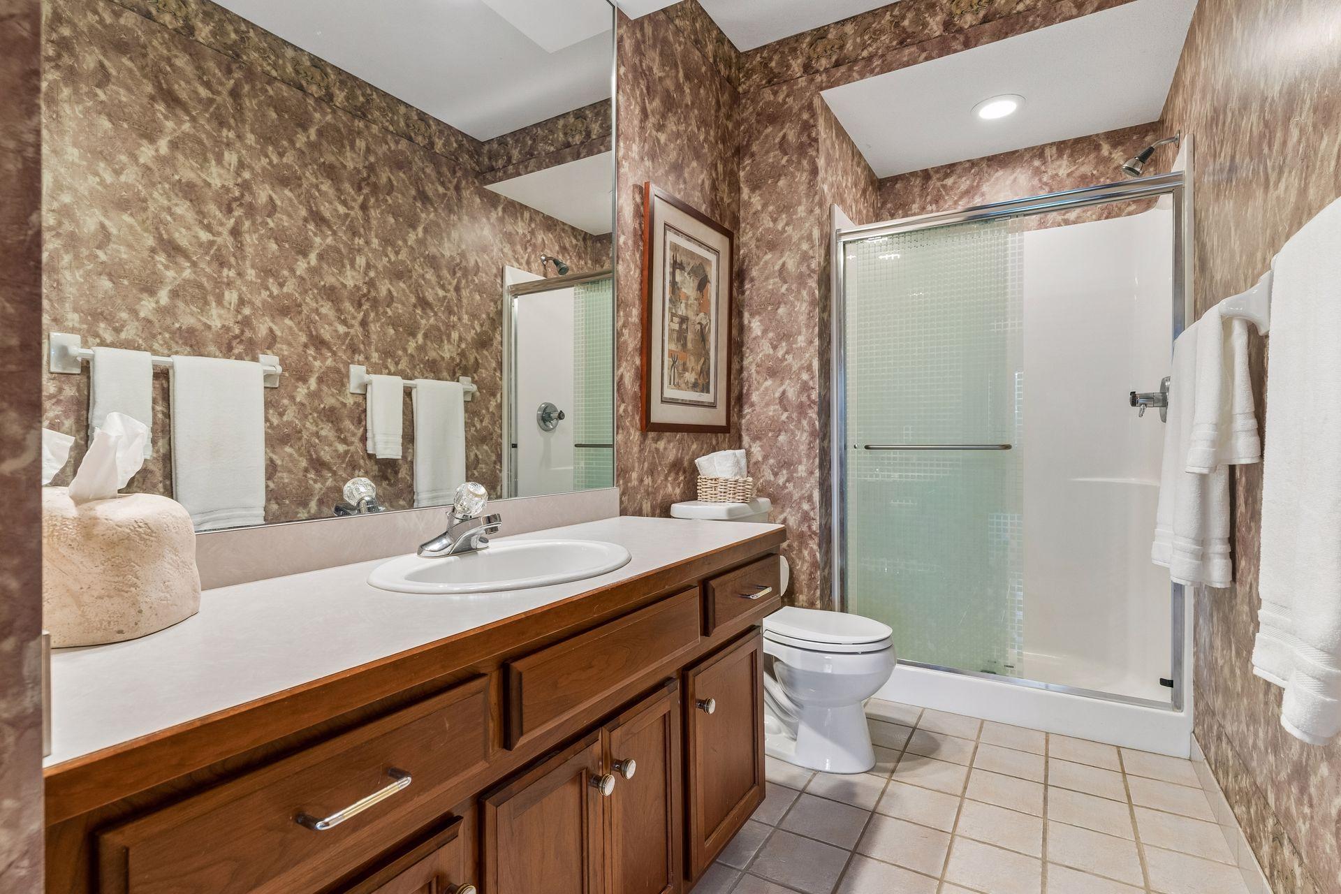 Lower level 3/4 bath with a tile floor and spacious vanity.