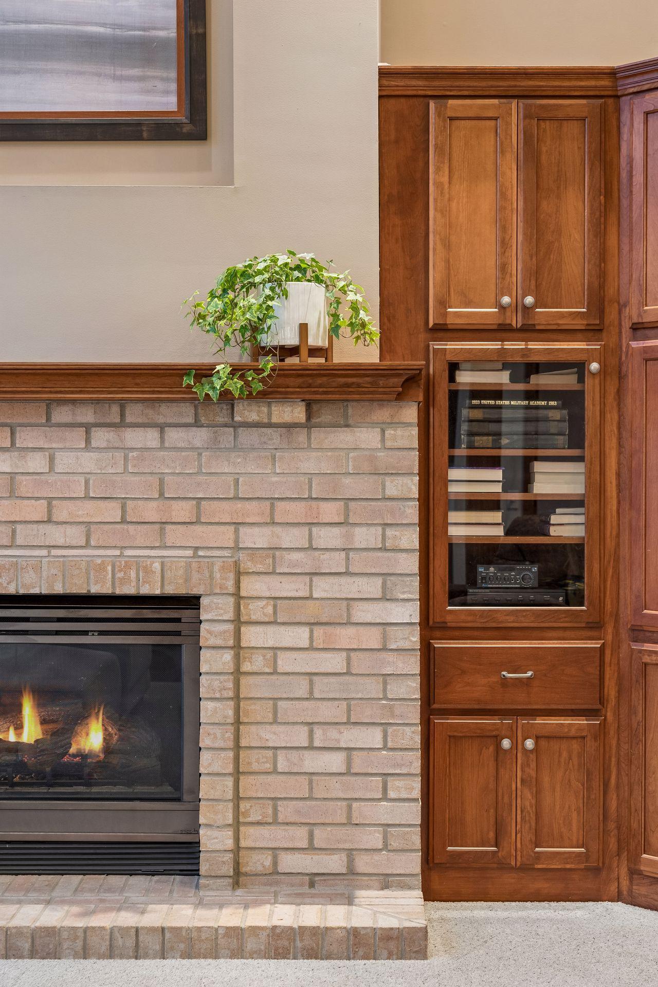 Beautiful brick fireplace with a handsome wood mantle, elegant art niche above and flanking custom built-in's.